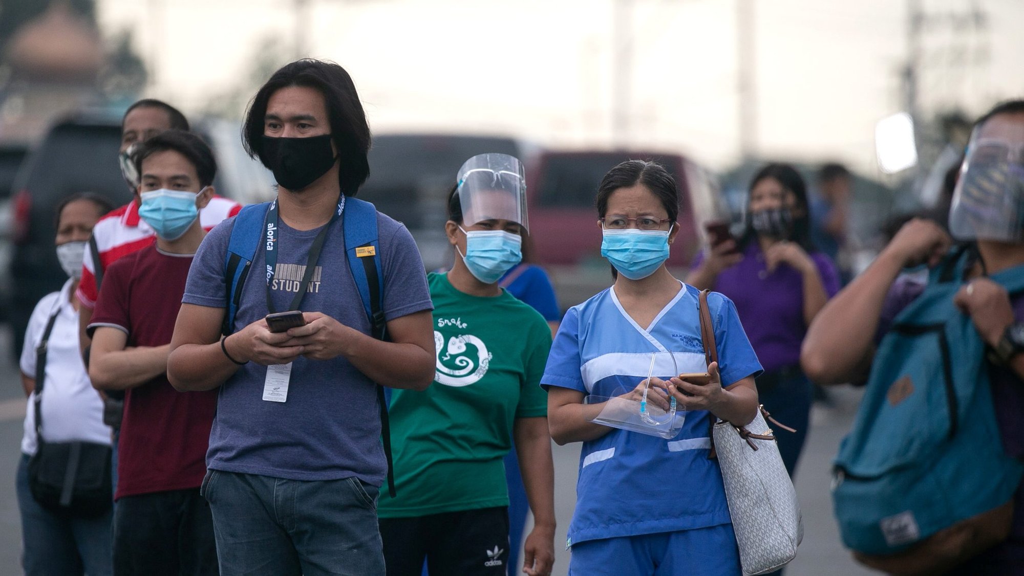 Workers wearing protective masks wait for shuttle services in Manila, Philippines, Aug. 4, 2020, the first day of the government's reimplementation of a stricter pandemic lockdown. (CNS photo/Eloisa Lopez, Reuters)