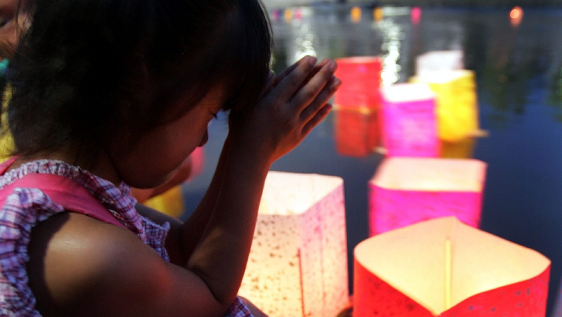 A girl prays after releasing a paper lantern on the Motoyasu River facing the gutted Atomic Bomb Dome in Hiroshima, Japan, Aug 6, 2020, the 75th anniversary of the U.S. dropping the atomic bomb on Hiroshima. (CNS photo/Yuriko Nakao, Reuters)
