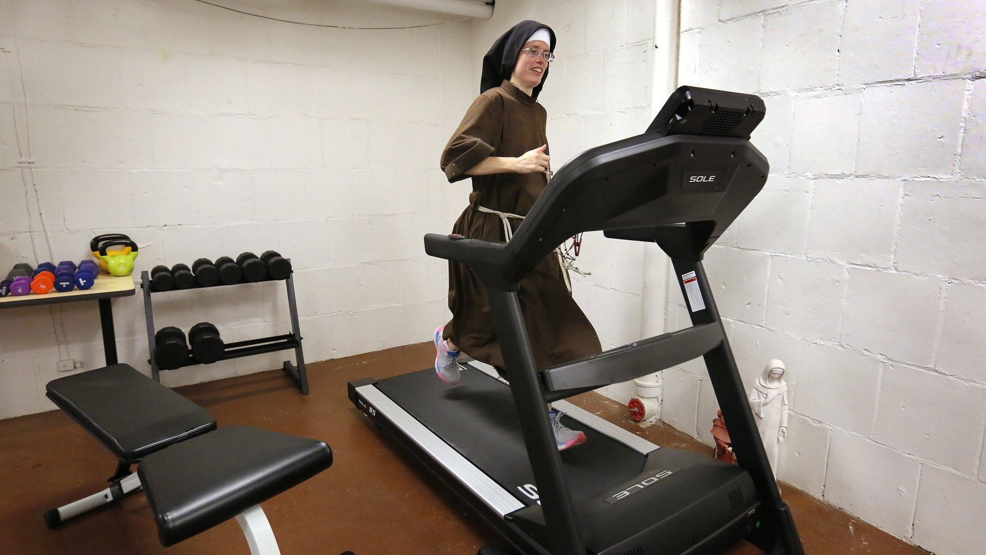 Sister Stephanie Baliga, a Franciscan Sister of the Eucharist of Chicago, runs on a treadmill in the basement of her community's convent Aug. 15, 2020. On Aug. 23 she will run a marathon on the treadmill to raise money for the Mission of Our Lady of the Angels and will attempt to set a world record for women's treadmill marathoning. (CNS photo/Karen Callaway, Chicago Catholic)