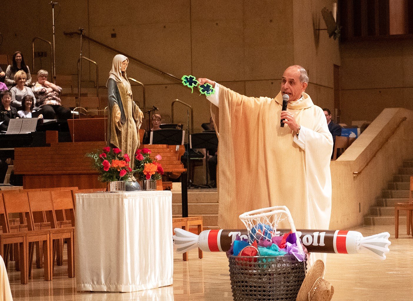 Outgoing Vicar General and Moderator of the Curia Msgr. Albert Bahhuth presents Bishop Joseph Brennan with some lighthearted parting gifts at the latter's farewell Mass before his installation as Bishop of Fresno in 2019. (Victor Alemán)