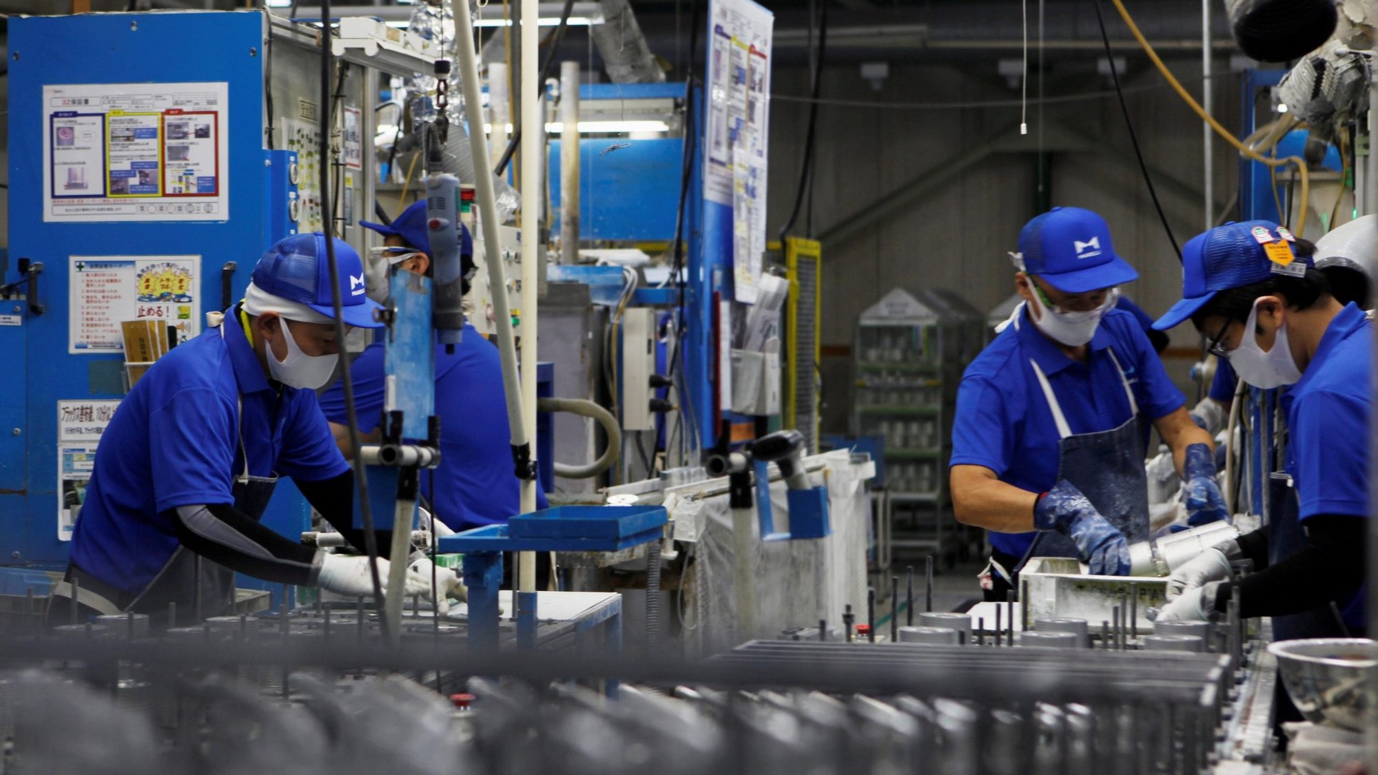 Workers wearing protective masks are pictured in a file photo along the assembly line at Marelli factory in Ora Town, Japan. (CNS photo/Naomi Tajitsu, Reuters)