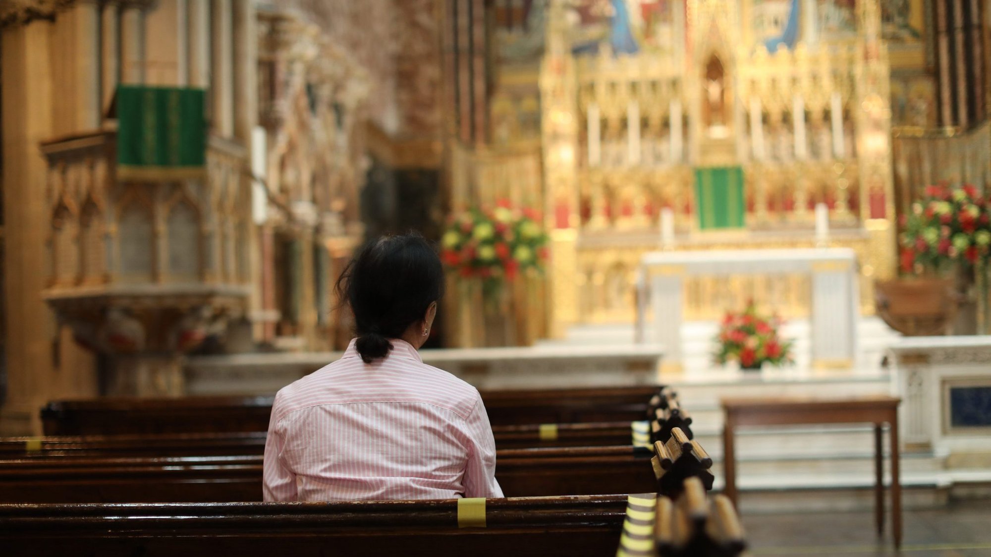 A woman is pictured in a file photo in the Catholic Church of the Immaculate Conception in London during the COVID-19 pandemic. (CNS photo/Isabel Infantes, PA Images via Reuters)