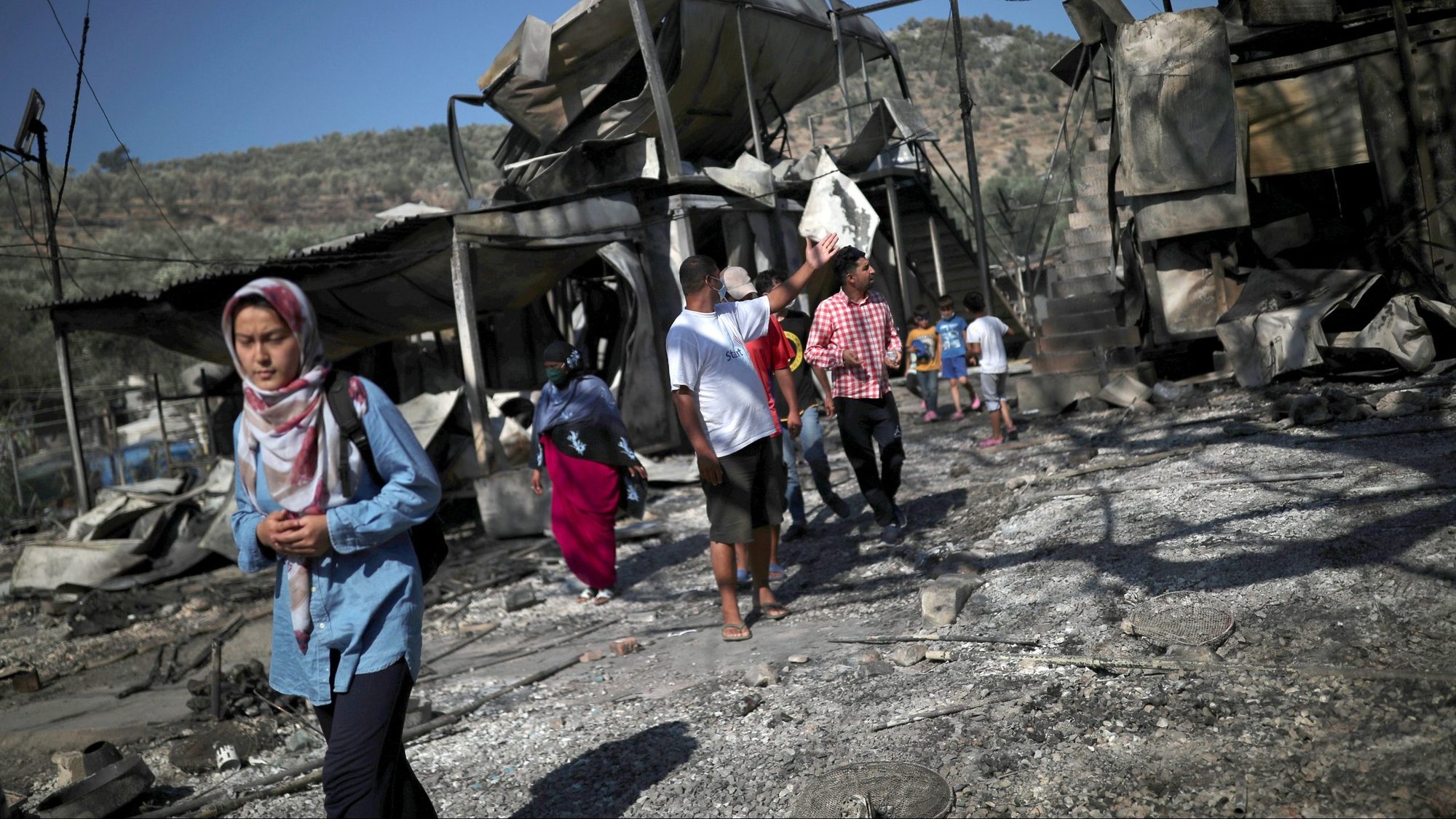 People look over destroyed shelters following a fire at the Moria refugee camp on the Greek island of Lesbos Sept. 9, 2020. The camp, which was mostly destroyed, was home to at least 12,000 people, six times its maximum capacity of just over 2,000 asylum-seekers. (CNS photo/Alkis Konstantinidis, Reuters)