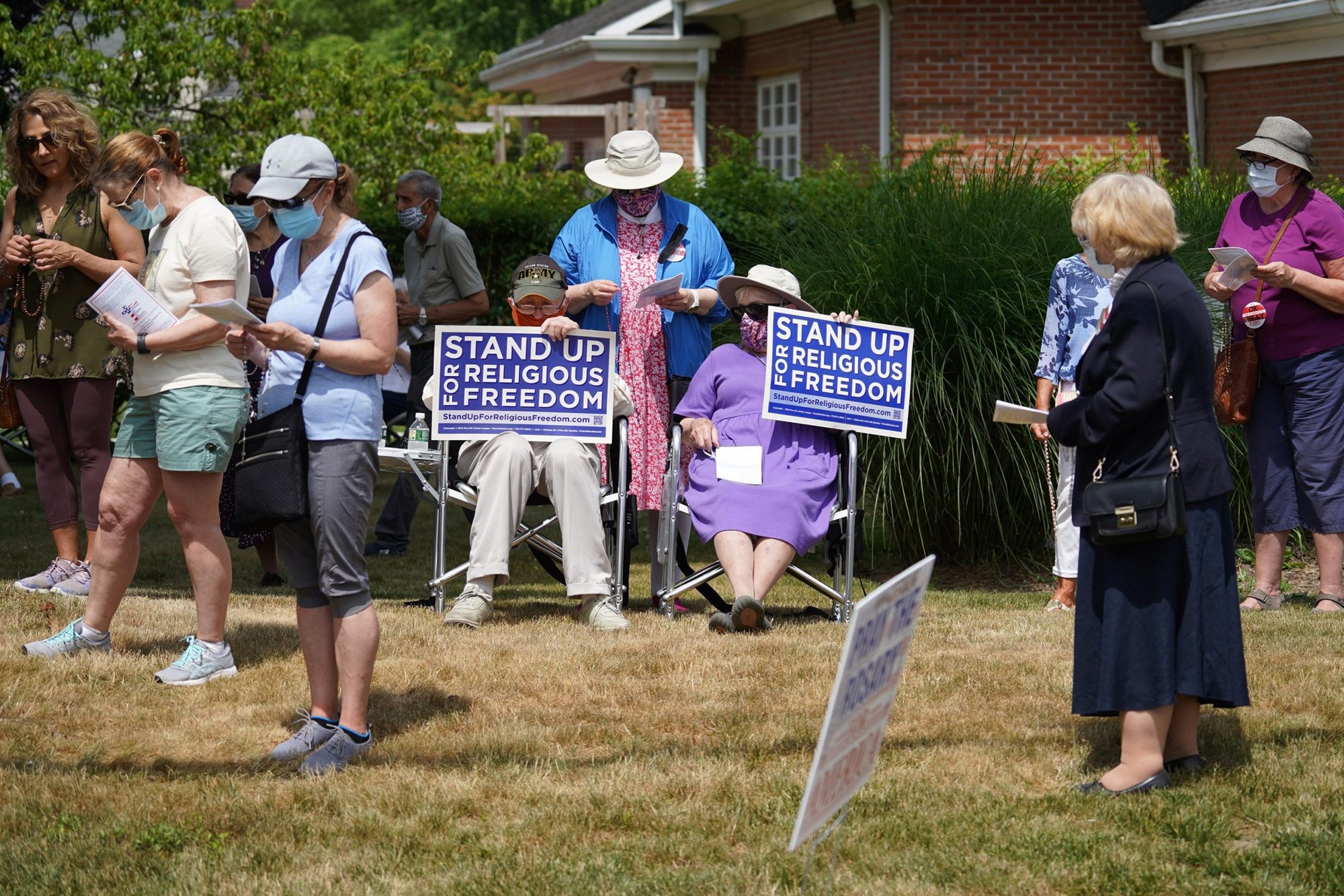 People recite the rosary while participating in a roadside prayer rally marking Religious Freedom Week at St. James Church in Setauket, New York, June 24. (Catholic News Service/Gregory A. Shemitz)