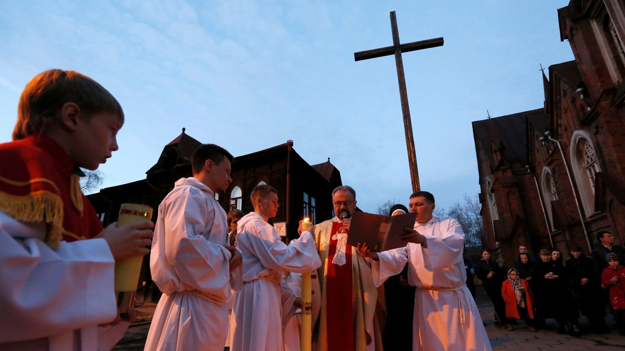 Clergymen and pilgrims pray outside Transfiguration Catholic Church on Holy Saturday, April 15, 2017, in Krasnoyarsk, Russia. Russia's Catholic Church leaders are warning against proposed curbs on the clergy. (CNS photo/Ilya Naymushin, Reuters)