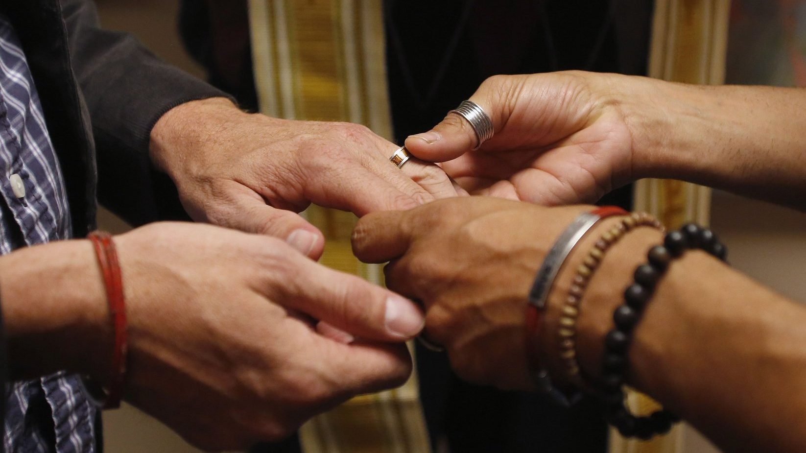 A same-sex couple is pictured in a file photo exchanging rings during a ceremony in Salt Lake City. In a new documentary, Pope Francis expressed openness to the idea of laws recognizing civil unions, including for gay couples, to protect their rights.(CNS photo/Jim Urquhar, Reuters)