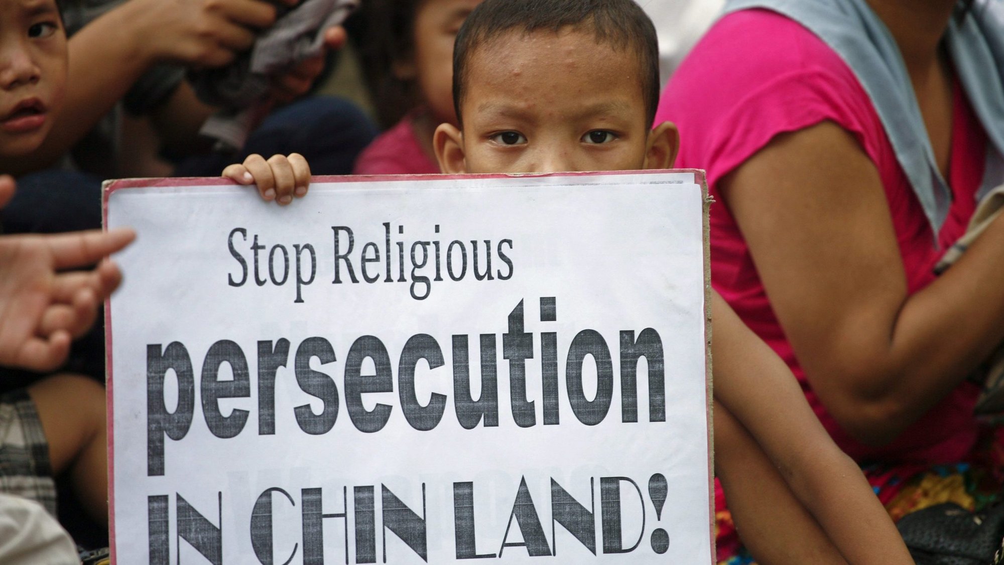 In this 2011 file photo, a young refugee from Myanmar's ethnic Chin minority holds a placard in New Delhi during a rally to mark World Refugee Day. (CNS photo/Parivartan Sharma, Reuters)