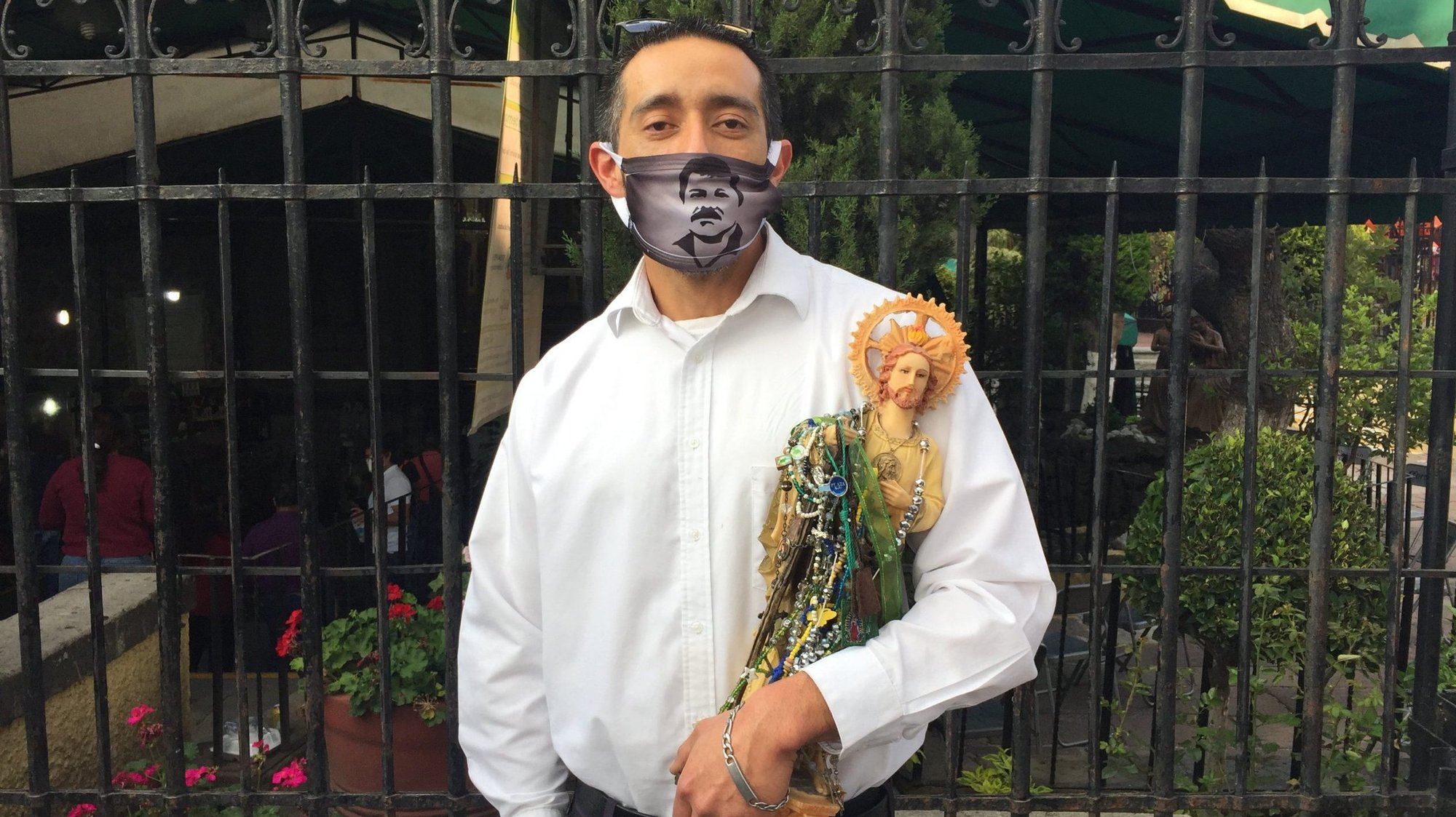 Arturo Rodriguez, wearing a protective mask, poses with a statue St. Jude Thaddeus in Mexico City in late September during the COVID-19 pandemic. Rodriguez credits the saint with curing an injured relative and brings the statue to a monthly celebration in Mexico City, where devotion is strong. (CNS photo/David Agren)