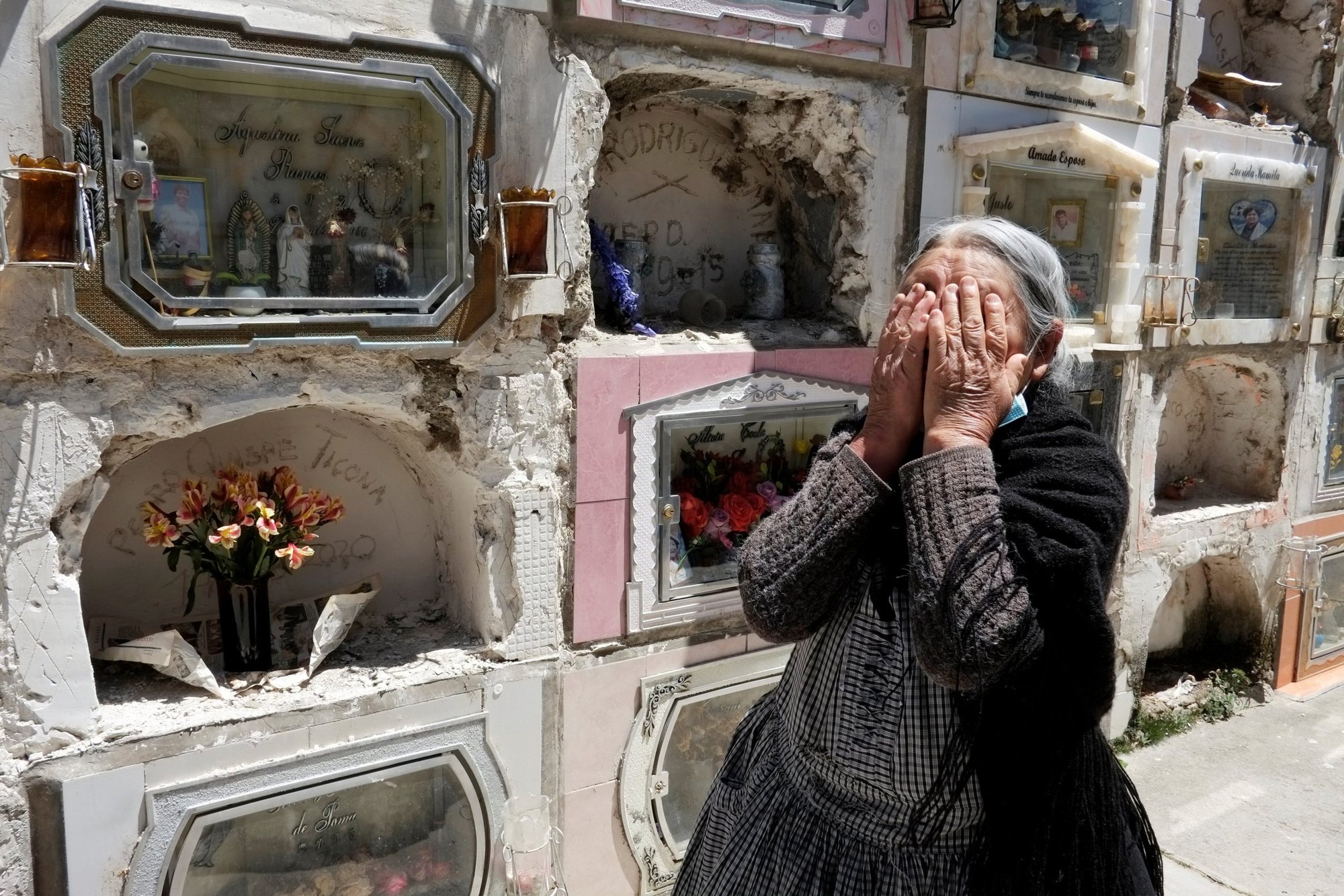 A woman reacts next to the grave of her husband at a cemetery in La Paz, Bolivia, Sept. 24, after the cemetery reopened for visitors during the coronavirus pandemic. (Catholic News Service/David Mercado, Reuters)