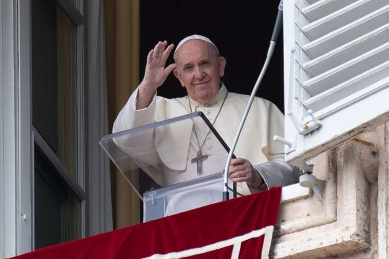Pope Francis waves from his window overlooking St. Peter’s Square during an Angelus address. (Vatican Media)