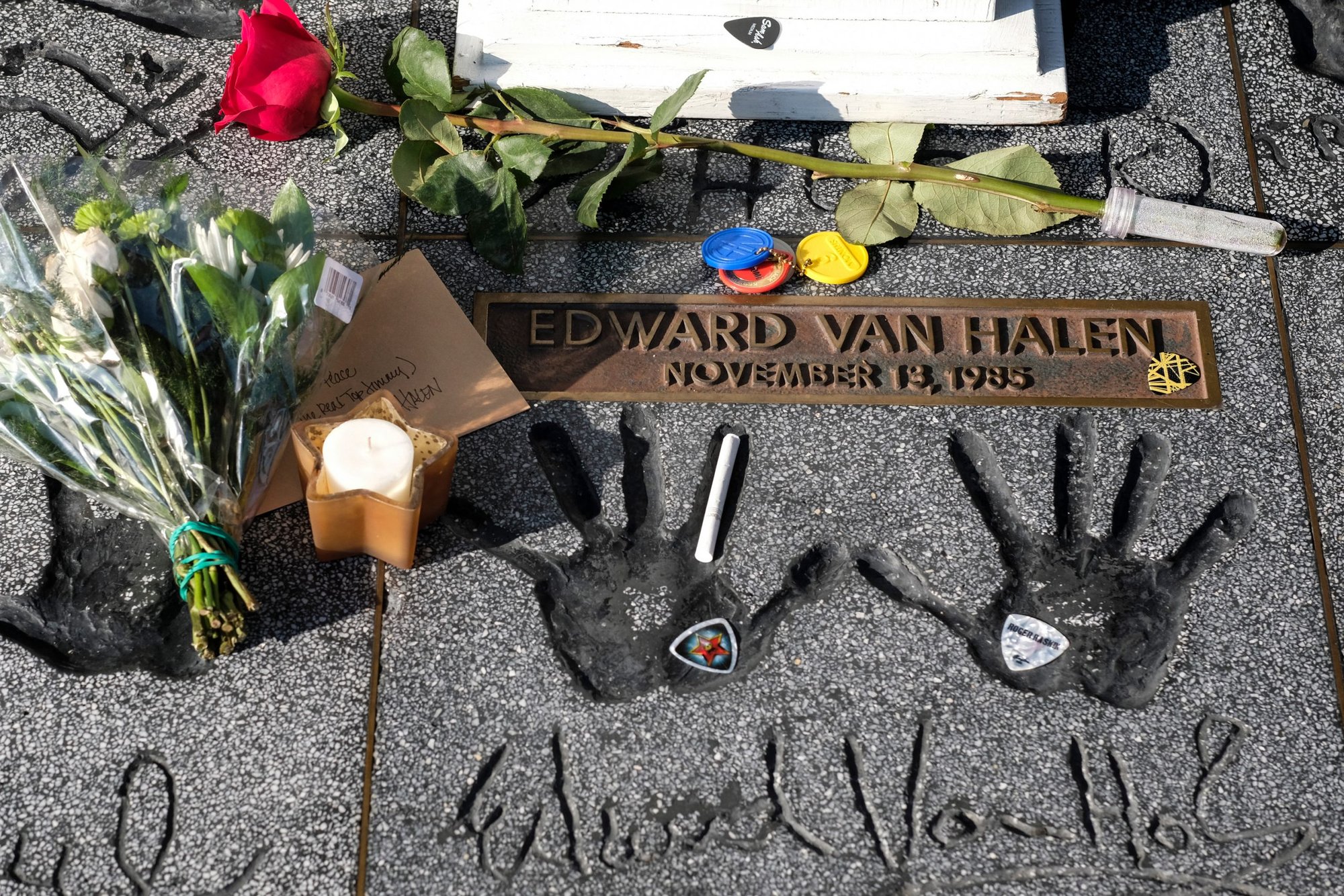 Flowers, a candle, and a cigarette are placed by Eddie Van Halen’s handprints at the California Rockwalk of Fame in Los Angeles Oct. 6. (Shutterstock)