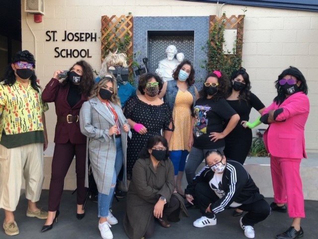 Teachers at St. Joseph School in La Puente pose in their 80s dance costumes after filming a video for students. Back row, L-R: Mark Padilla, Hazell Castaneda, Denay Galos, Manny Carmona, Marisela Sahagun, Diana Torres, Stacy Acuna, Laura Sanchez, and principal Luis Hayes. Front row, kneeling, L-R: Geresa Silva and Desiree Contreras. (Carmen Ramirez, St. Joseph School)