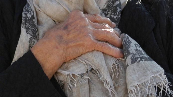 An elderly woman's hands are seen in this photo. Many residents of nursing facilities are now isolated because of COVID-19. (Paul Haring/CNS via Crux)