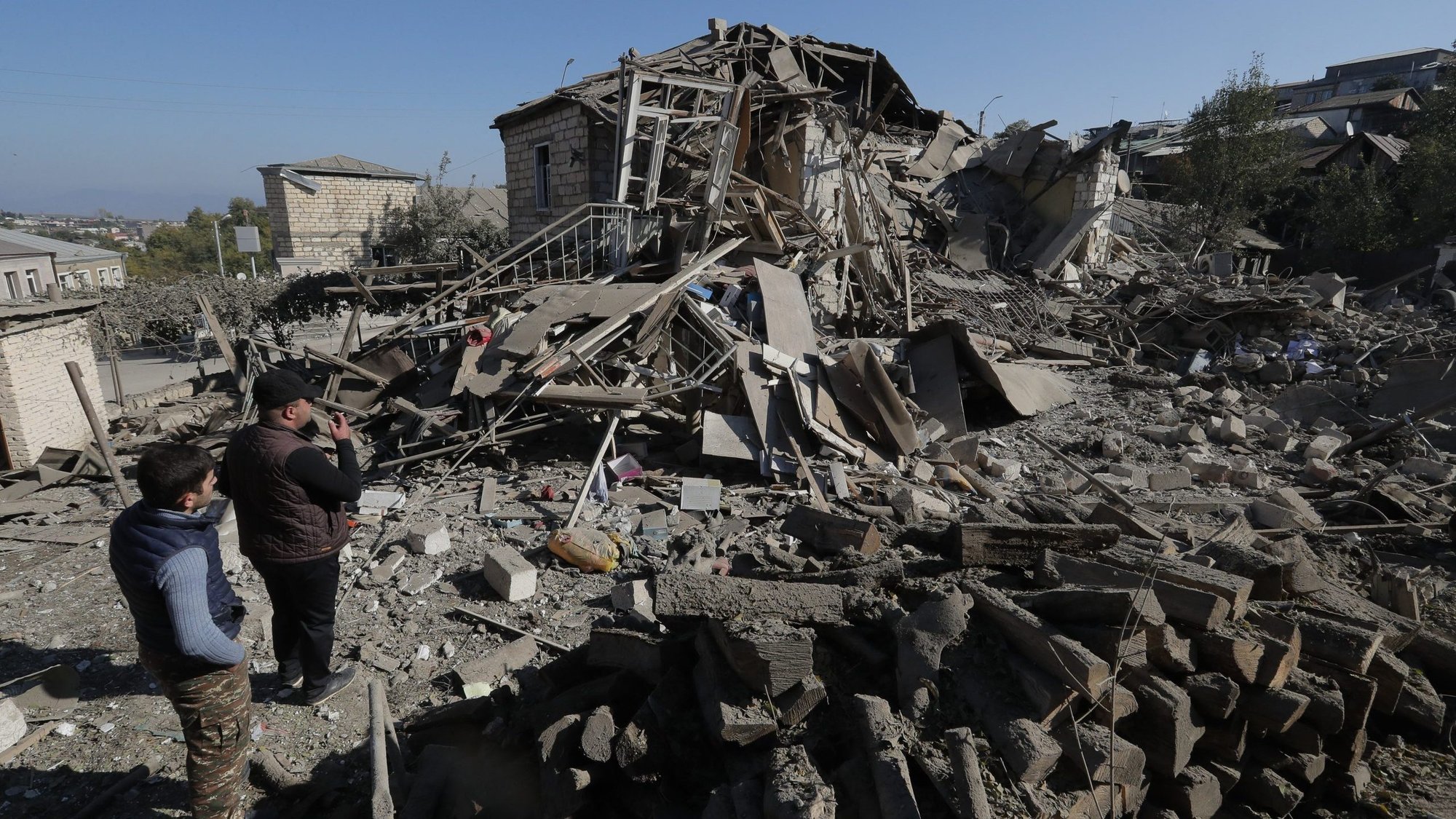Men look at the ruins of a house in Stepanakert, Azerbaijan, Oct. 17, 2020, following recent shelling during a military conflict over the breakaway region of Nagorno-Karabakh. (CNS photo/Reuters)