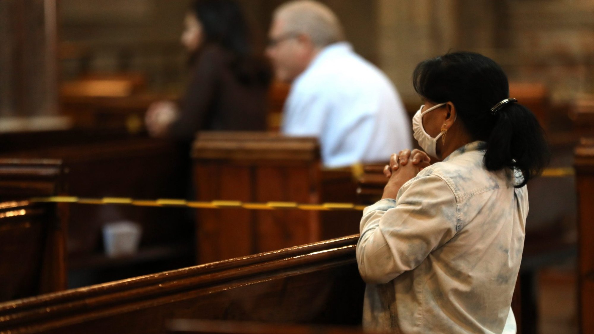 A woman wearing a protective mask prays during Mass at the Catholic Church of the Immaculate Conception in London July 4, 2020, during the COVID-19 pandemic. Catholic leaders in England are appealing to the government to reverse its decision to ban public Mass during a second national lockdown. (CNS photo/Isabel Infantes, PA Images via Reuters)
