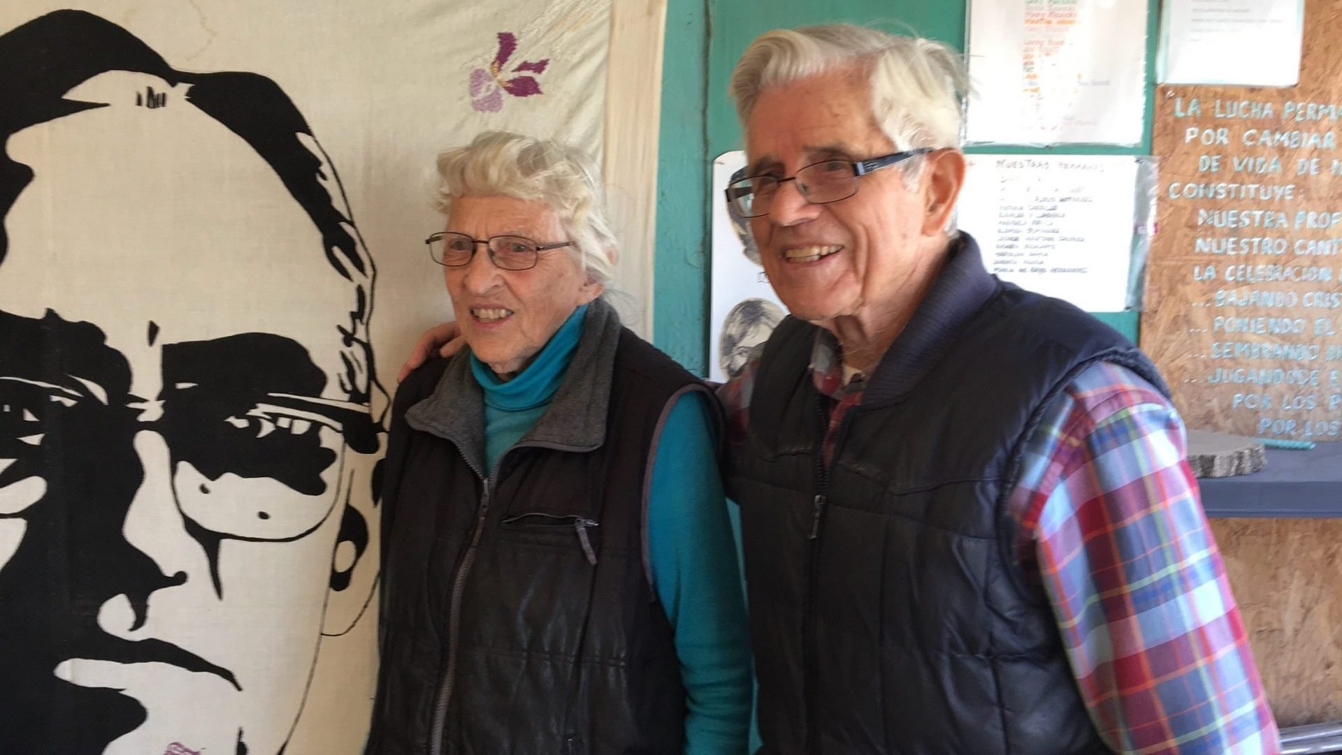 Mercy Sister Betty Campbell and Carmelite Father Peter Hinde pose next to an illustration of St. Oscar Romero in a 2019 photo in Ciudad Juarez, Mexico. Father Hinde and Sister Campbell will receive the CRISPAZ Peace Award Nov. 17 for their decades of ministry and social justice work in Latin America. (CNS photo/Julie Bourbon, courtesy Sisters of Mercy of the Americas)