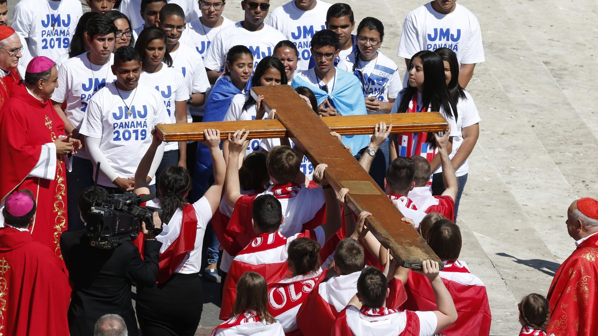 Youths from Poland present the World Youth Day cross to young representatives from Panama at the conclusion of Palm Sunday Mass celebrated by Pope Francis in St. Peter's Square at the Vatican in this April 9, 2017, file photo. Young people from Panama will pass the World Youth Day cross to their Portuguese peers Nov. 22 at the end of Pope Francis' Mass for the feast of Christ the King. (CNS photo/Paul Haring)