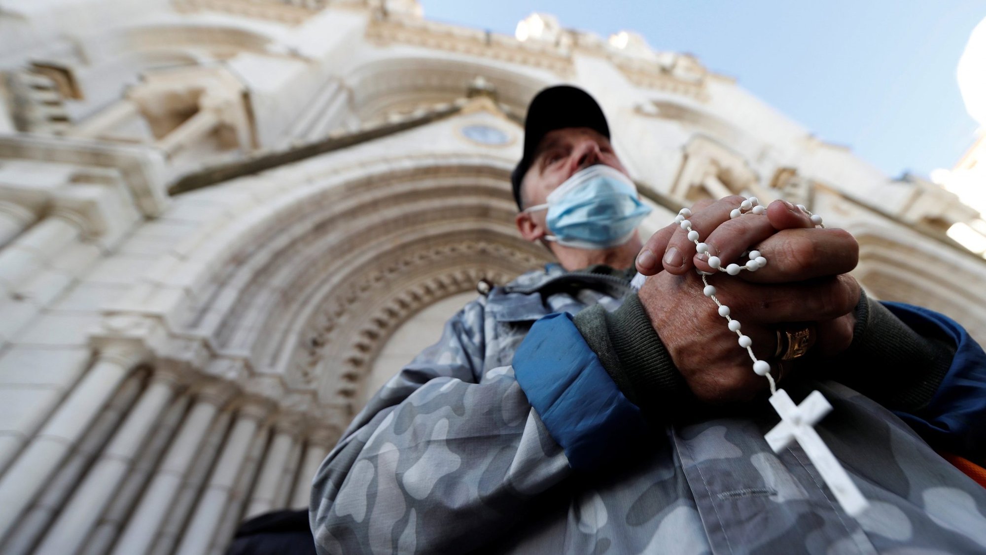 A man prays with a rosary outside Notre Dame Basilica in Nice, France, Oct. 30, 2020, the day after three people were stabbed to death inside. (CNS photo/Eric Gaillard, Reuters)