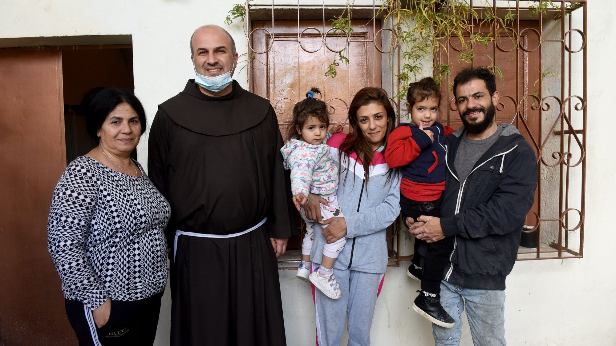 Franciscan Father Rami Asakrieh, pastor of St. Catherine Church in Bethlehem, West Bank, poses with the Zablah family Dec. 1, 2020, in Bethlehem. Pictured with Father Asakrieh from left to right are: Kathy, 53, Tolay, who turns 2 Dec. 23, Tamara, 32, Tala, 4, and Tamer, 32. (CNS photo/Debbie Hill)