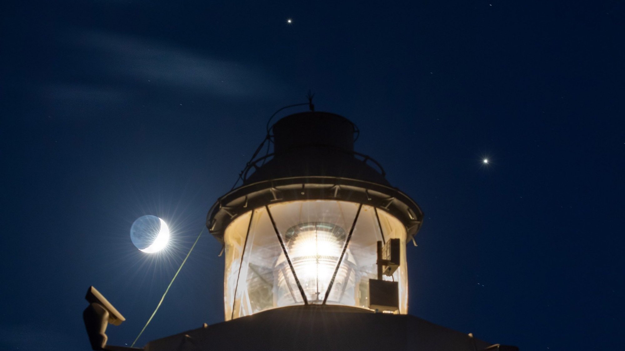 Saturn is seen shining above the Cape Murro di Porco Lighthouse in Syracuse, Sicily, and Jupiter is seen shining to the right, in this photo taken in November 2020. The two largest planets in the solar system will pass so close together in Earth's sky that the moon will easily be able to cover them both simultaneously Dec. 21. This pending planetary passage will be the closest since 1623. (CNS photo/Kevin Saragozza, courtesy NASA)