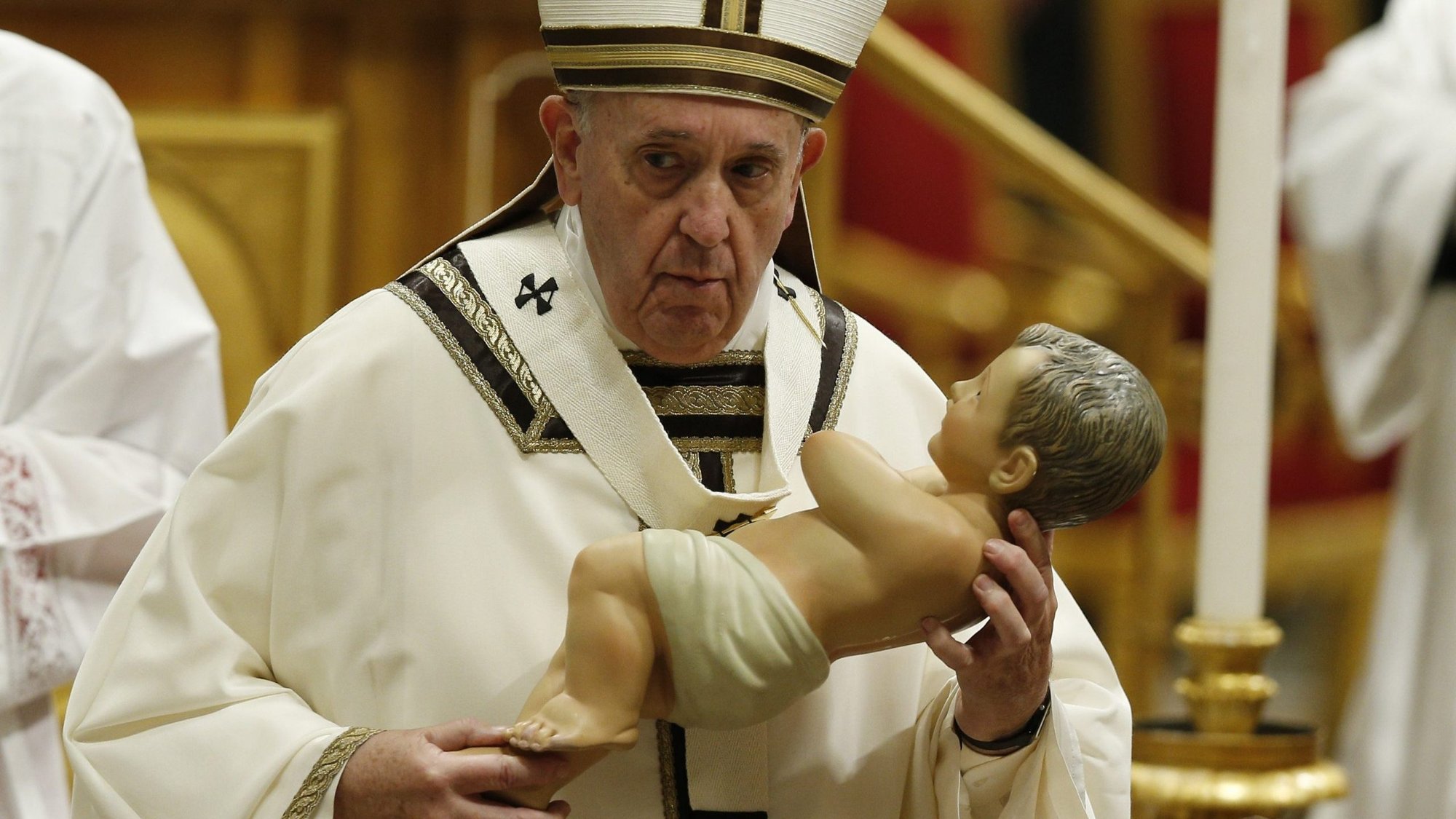 Pope Francis carries a figurine of the baby Jesus as he leaves Christmas Mass in St. Peter's Basilica at the Vatican in this Dec. 24, 2019, file photo. The pope will celebrate the traditional Christmas Eve Mass with a small congregation; the Mass will begin at 7:30 p.m. in Rome so people can get home without breaking Italy's 10 p.m. COVID-19 curfew. (CNS photo/Paul Haring)