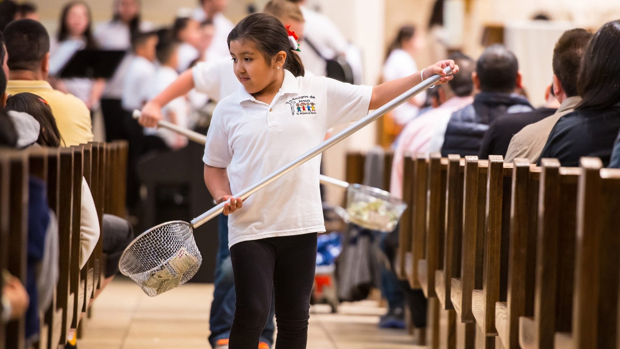 Yelixa Hernandez, a member of the Hispanic youth group, helps collect donations during Mass at St. Willebrord Church in Green Bay, Wis., April 26, 2015. (CNS photo/Sam Lucero, The Compass)
