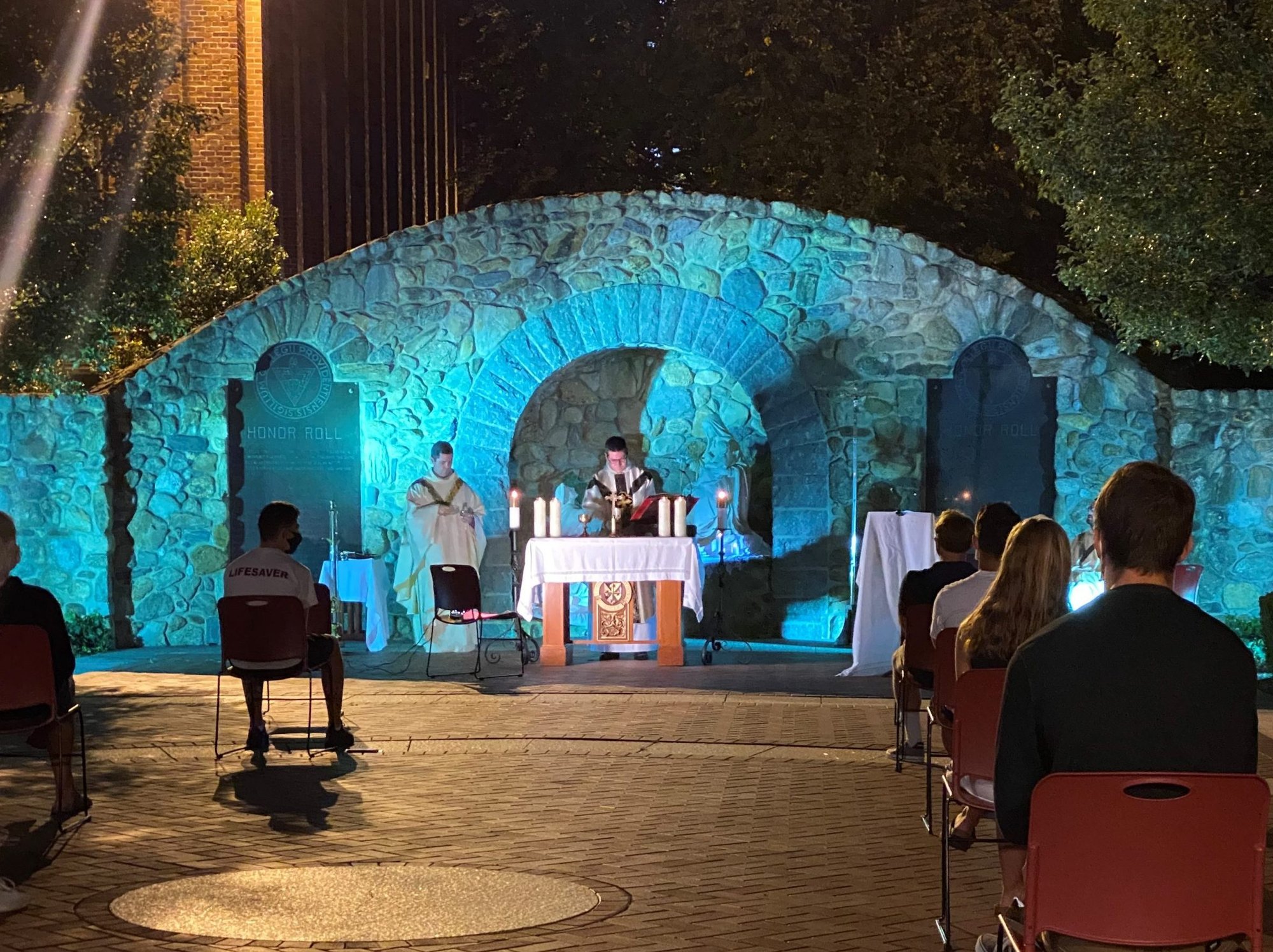 Father Briscoe and another priest celebrate outdoor Mass for students at Providence College's Rosary Grotto. (Submitted photo)
