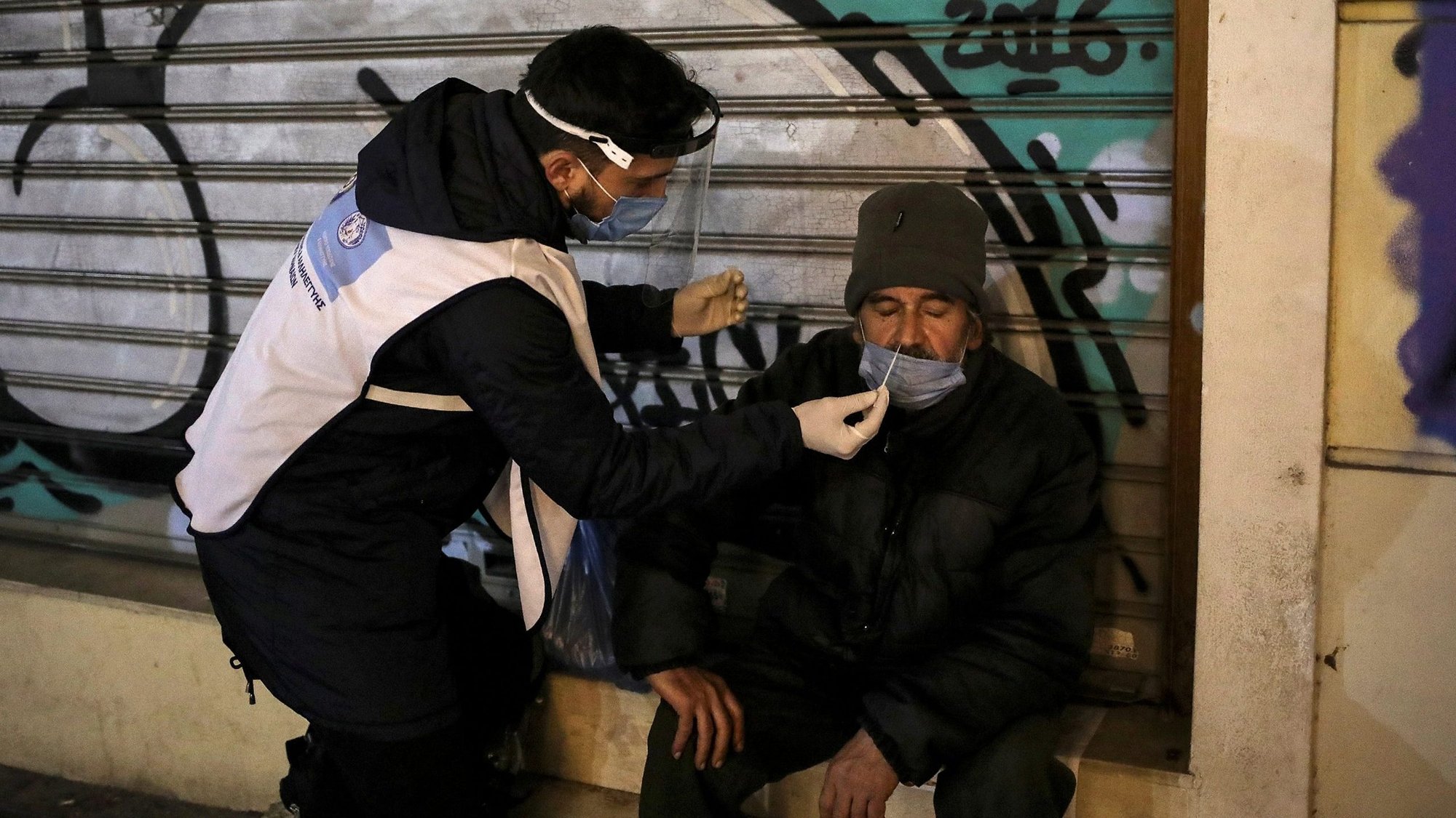 A health care worker takes a swab from a homeless man for a rapid antigen COVID-19 test in Athens, Greece, Dec. 21, 2020. In his message for the Feb. 11 celebration of the World Day of the Sick, Pope Francis called on Christians to practice what they preach, including by guaranteeing equal access to health care for all people. (CNS photo/Costas Baltas, Reuters)