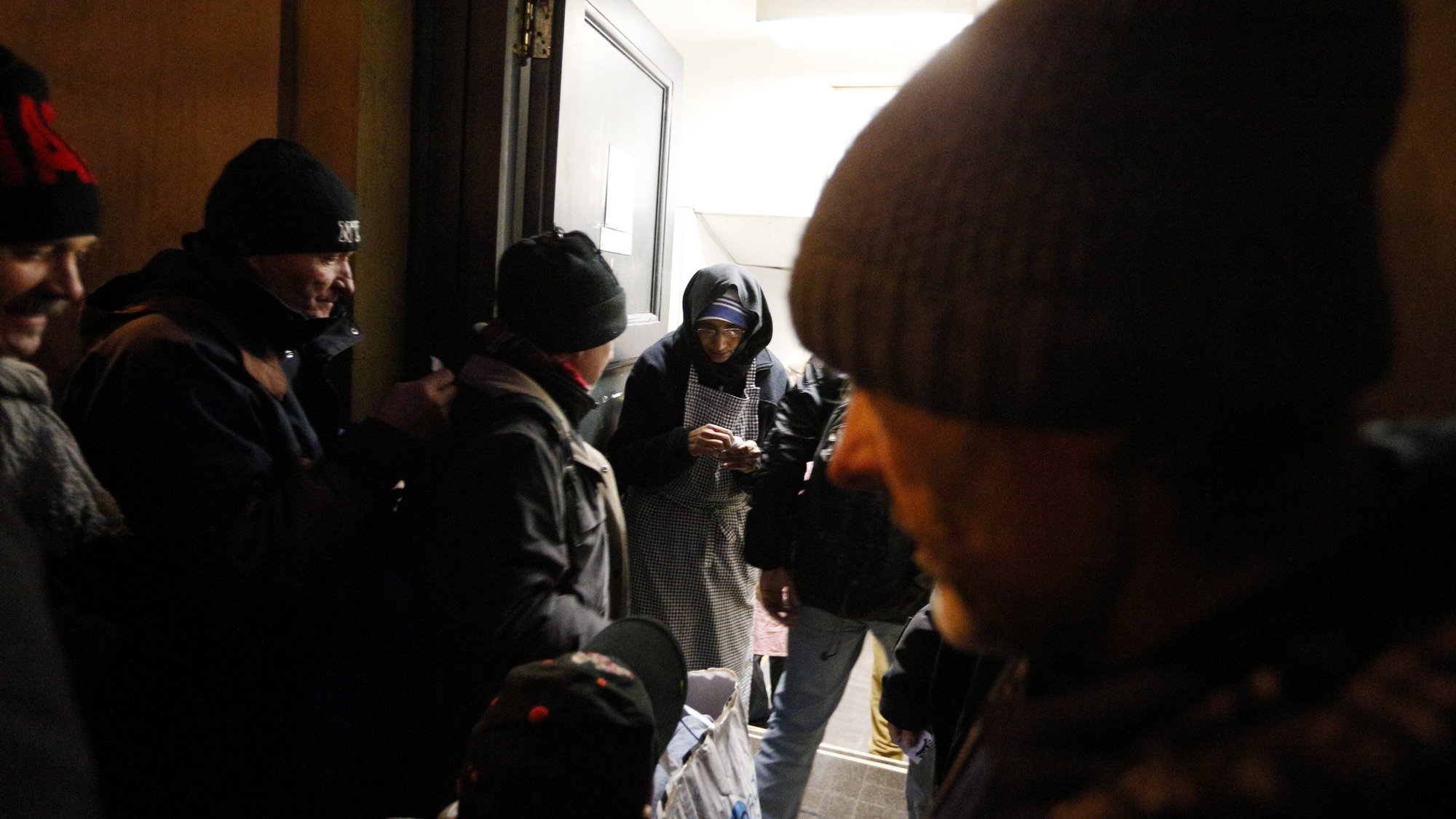 A Missionaries of Charity nun stands in the doorway as men enter a center run by the order for an evening meal at the Vatican in this Jan. 7, 2017, file photo. (CNS photo/Paul Haring)