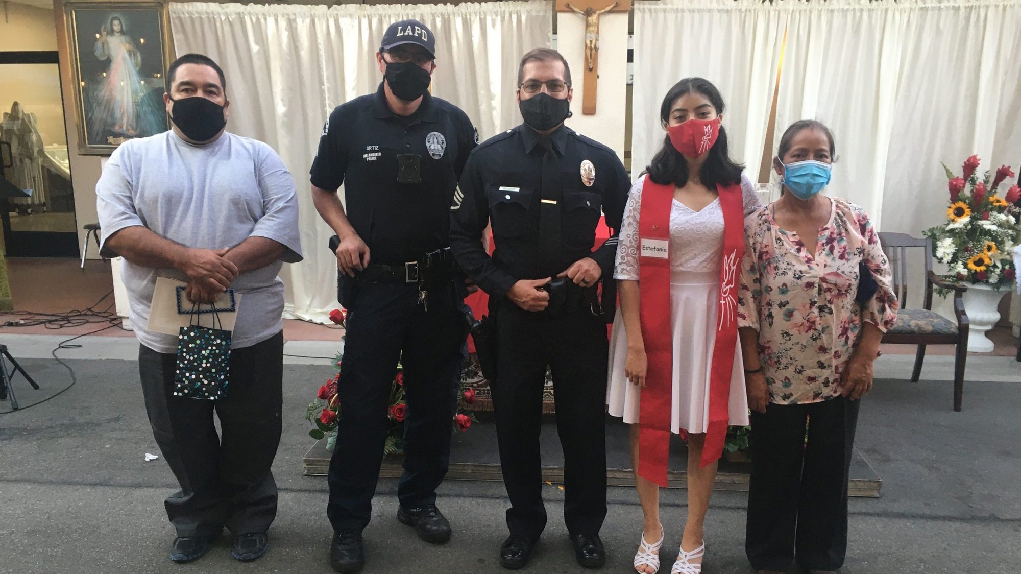 Estefiana Torres, second from right, at her Sept. 18 confirmation ceremony at St. Lawrence of Brindisi Church in Watts. From left: Her father, Luis Torres; LAPD officers Eric Ortiz and Ken Busiere, and Estefiana’s mother, Francisca Arenas, far right. (Father Matt Elshoff)