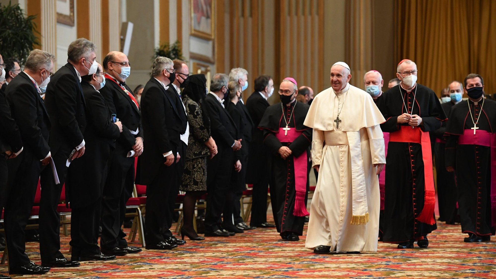 Pope Francis walks near diplomats accredited to the Holy See during an audience in the Hall of Blessings at the Vatican Feb. 8, 2021. In his annual address to the diplomatic corps, the pope said that the COVID-19 pandemic can either be a catalyst toward achieving a better world or a cause to further weaken a world burdened by global crises. (CNS photo/Vatican Media)