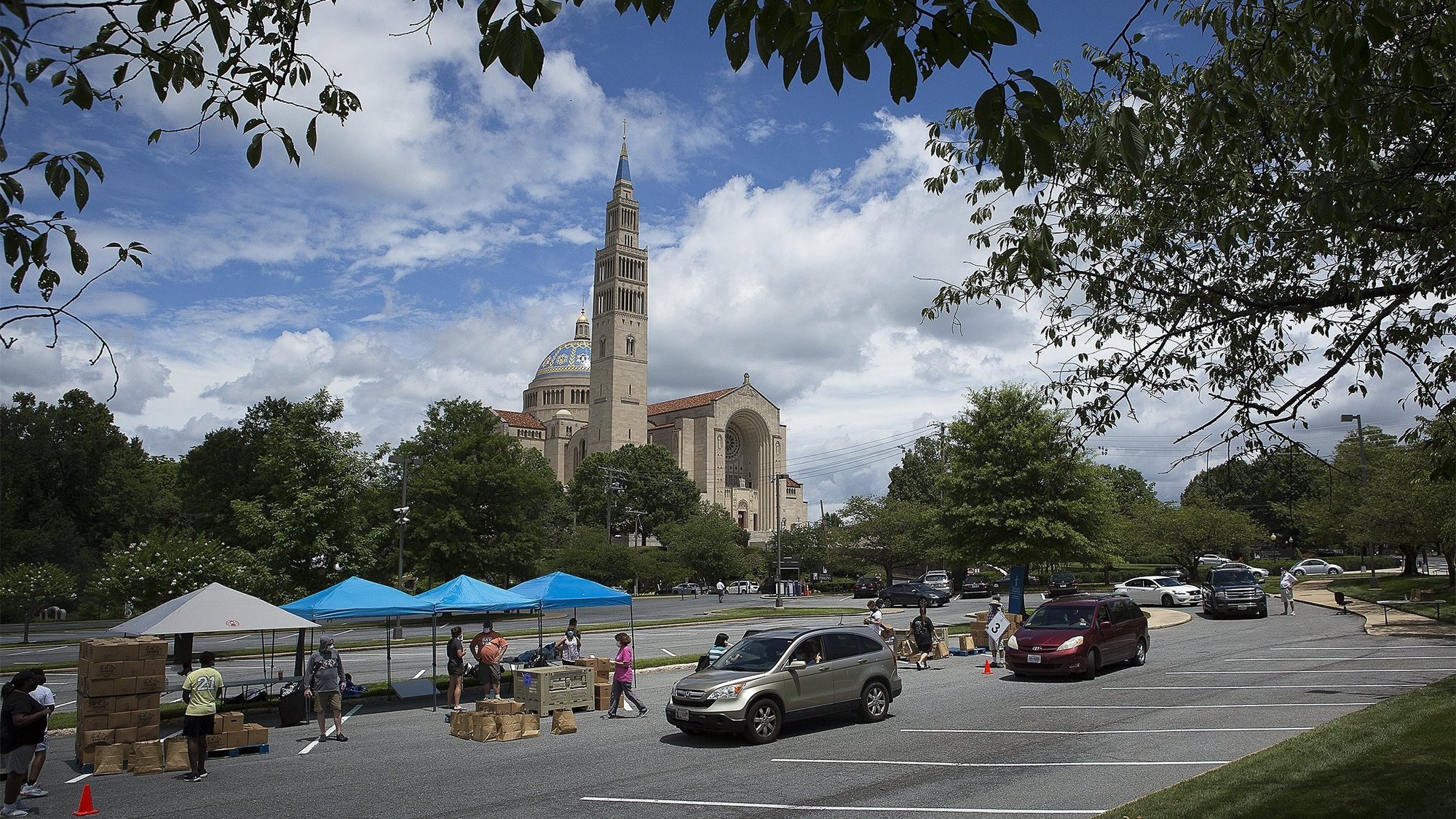 Catholic Charities staff and volunteers in the Archdiocese of Washington distribute 500 grocery boxes and 500 family meals in the parking lot of the Basilica of the National Shrine of the Immaculate Conception July 10, 2020, during the coronavirus pandemic. (CNS photo/Tyler Orsburn)