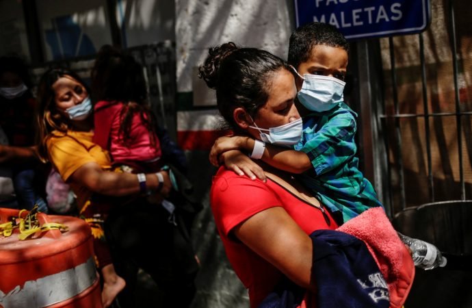 Asylum-seeking migrants from Central America who were airlifted from Brownsville, Texas, to El Paso, and later deported, walk outside a National Institute of Migration office at the Paso del Norte International Bridge in Ciudad Juárez, Mexico, March 23, 2021. (Jose Luis Gonzalez/Reuters via CNS)