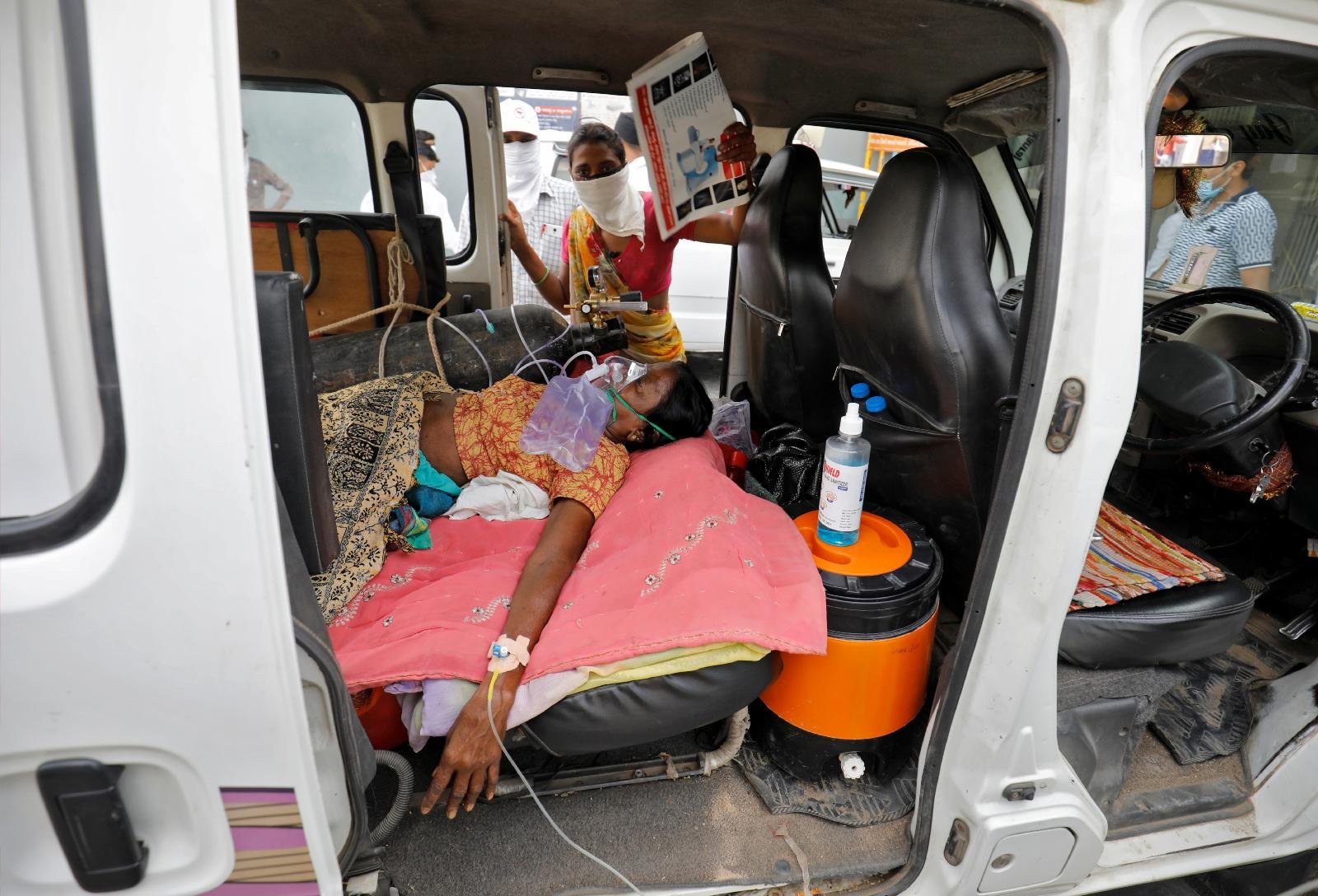 A patient wearing an oxygen mask lies inside a vehicle while waiting to enter a COVID-19 hospital for treatment in Ahmedabad, India, April 26, 2021. (CNS photo/Amit Dave, Reuters)