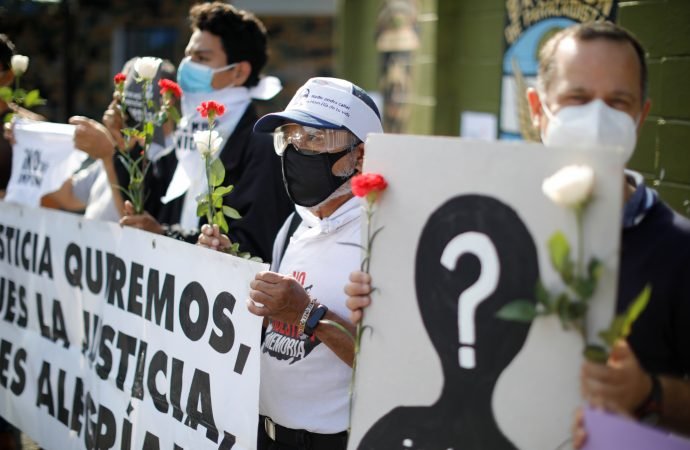 People are pictured in a file photo protesting outside El Salvador's Ilopango Air Base after the military rejected a request by a judge to access files on the 1981 El Mozote massacre, in which nearly 1,000 civilians were killed by U.S.-trained soldiers. (Jose Cabezas/Reuters via CNS)