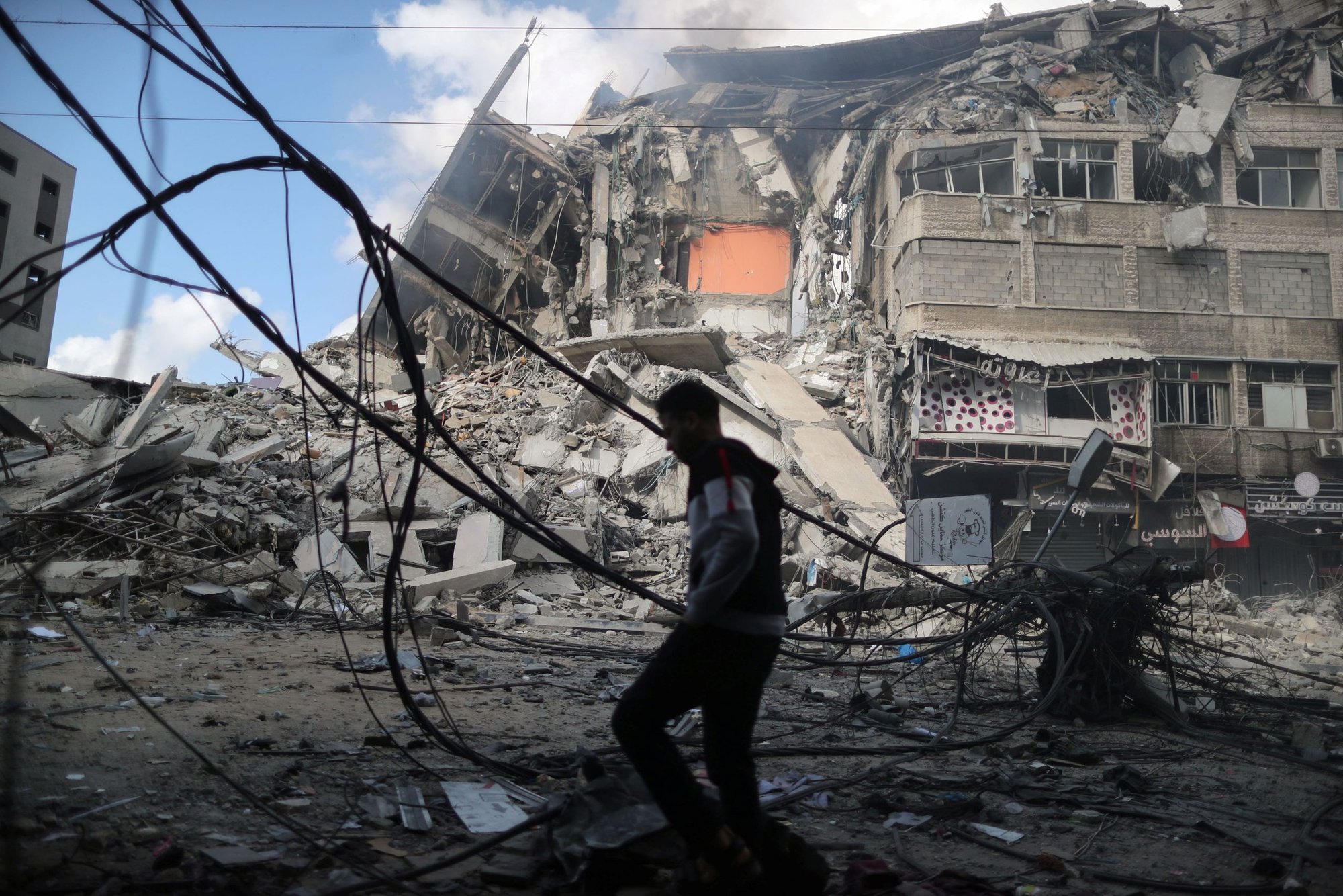 A Palestinian man walks past the remains of a tower building in the aftermath of Israeli airstrikes on the first day of Eid al-Fitr, in Gaza City May 13, 2021. (CNS photo/Suhaib Salem, Reuters)