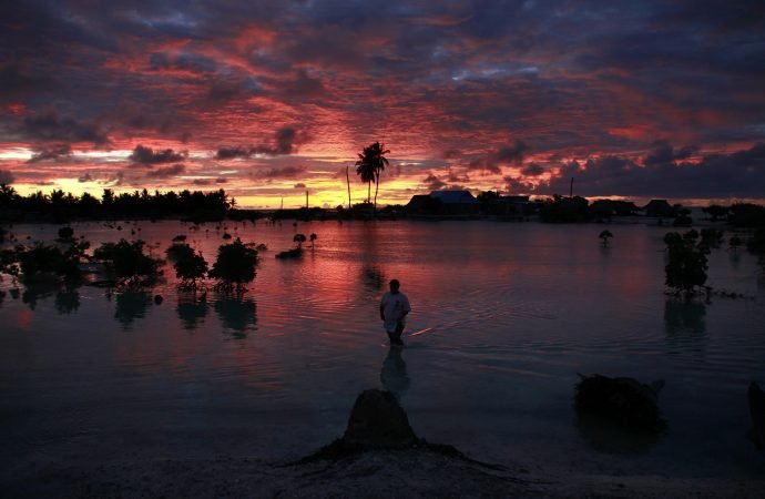 A villager wades through a small lagoon, which at high tide laps at the base of homes, near the village of Tangintebu on South Tarawa in the central Pacific island nation of Kiribati May 25, 2013. Pope Francis said island nations need protection from extreme environmental and climate changes. (David Gray/Reuters via CNS)