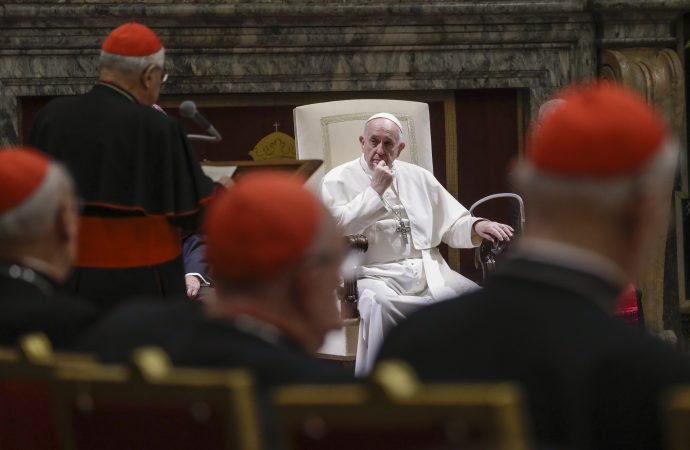 In this Dec. 21, 2019 file photo, Pope Francis listens to Cardinal Angelo Sodano, standing at left with back to camera, as he delivers his speech on the occasion of the pontiff's Christmas greetings to the Roman Curia, in the Clementine Hall at the Vatican. Pope Francis sent a message to Vatican-based cardinals on Friday about his intent to hold them accountable for criminal misconduct, removing the legal obstacles that had prevented them from ever being prosecuted by the Vatican’s criminal tribunal. (AP Photo/Andrew Medichini, Pool via Crux)