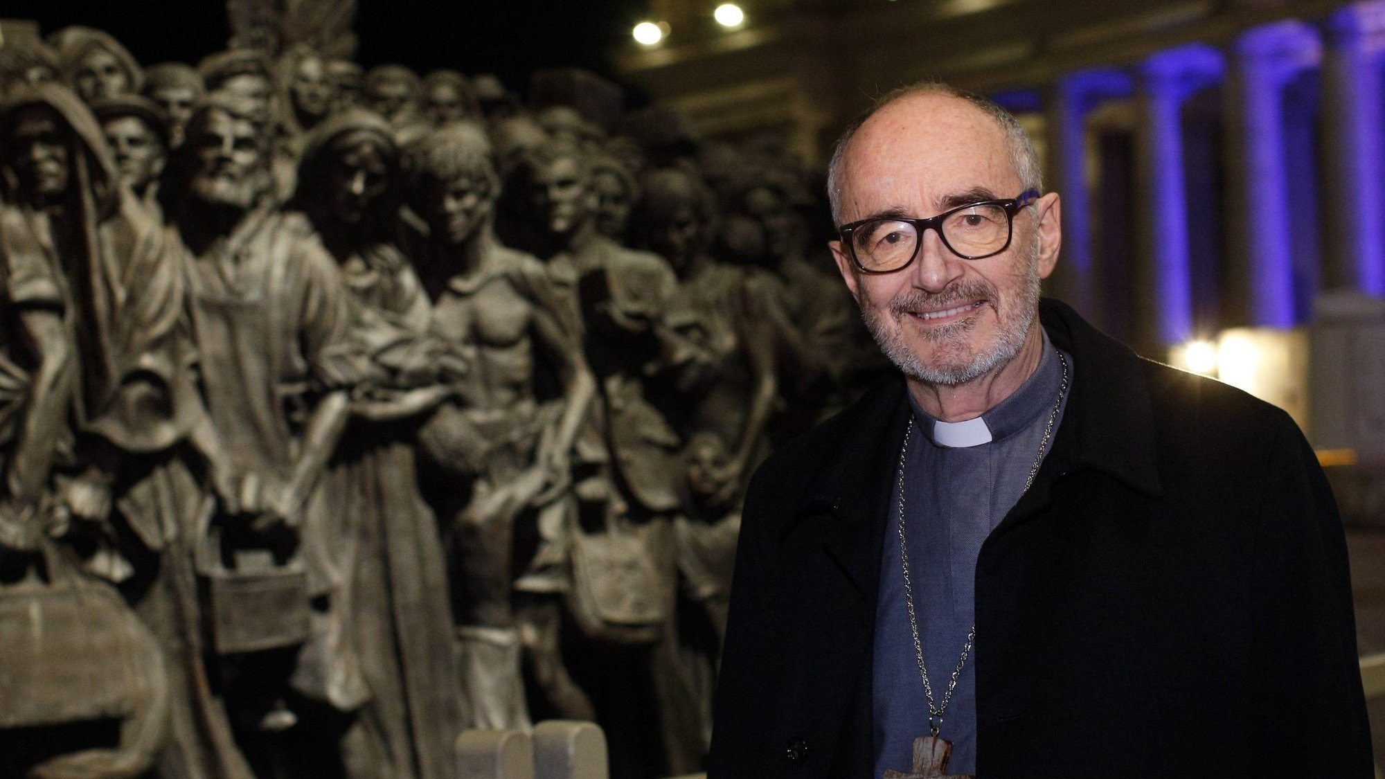 Cardinal Michael Czerny, undersecretary for migrants and refugees at the Vatican Dicastery for Promoting Integral Human Development, poses for a photo at the "Angels Unawares" statue in St. Peter's Square at the Vatican Dec. 15, 2020. (CNS photo/Paul Haring)