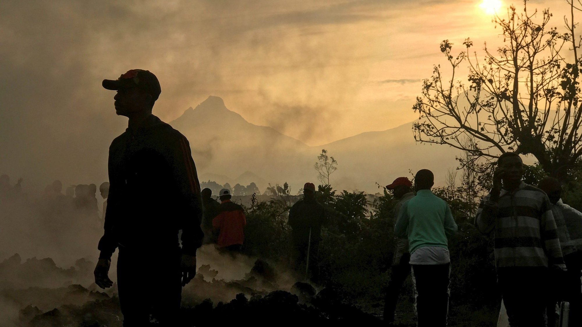 Smoke rises as residents walk near homes destroyed by lava deposited by the eruption of Mount Nyiragongo in Goma, Congo, June 6, 2021. The Congolese bishops have sharpened their focus on protecting the Congo Basin. (CNS photo/Djaffar Al Katanty, Reuters)