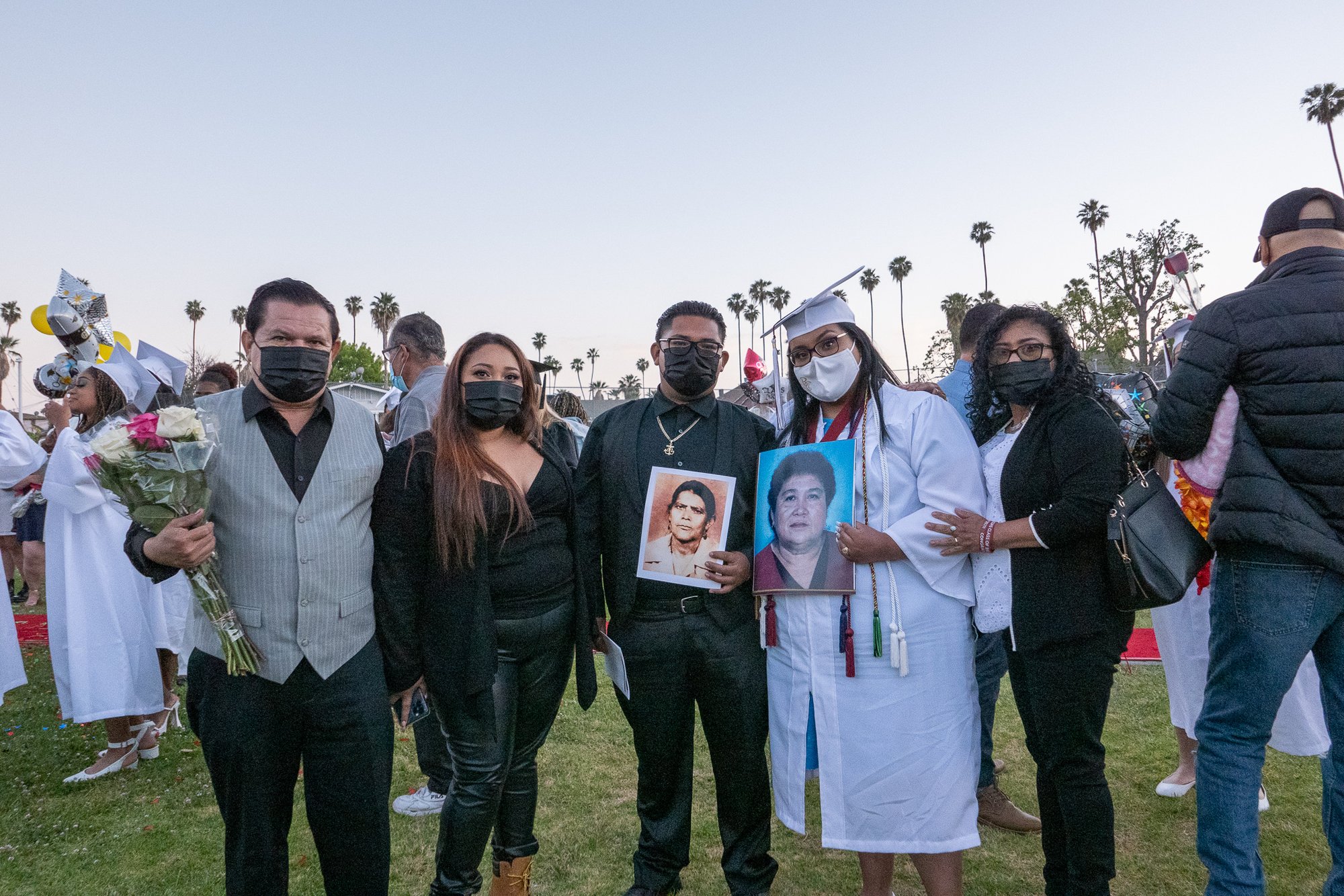 The Marroquin family at Jeaneth's graduation from Bishop Conaty-Our Lady of Loretto High School May 28. Jeaneth, fourth from left, holds a picture of her grandmother, Maria Fulgencia, who died of COVID-19 last fall. (JohnMichael Fillipone)
