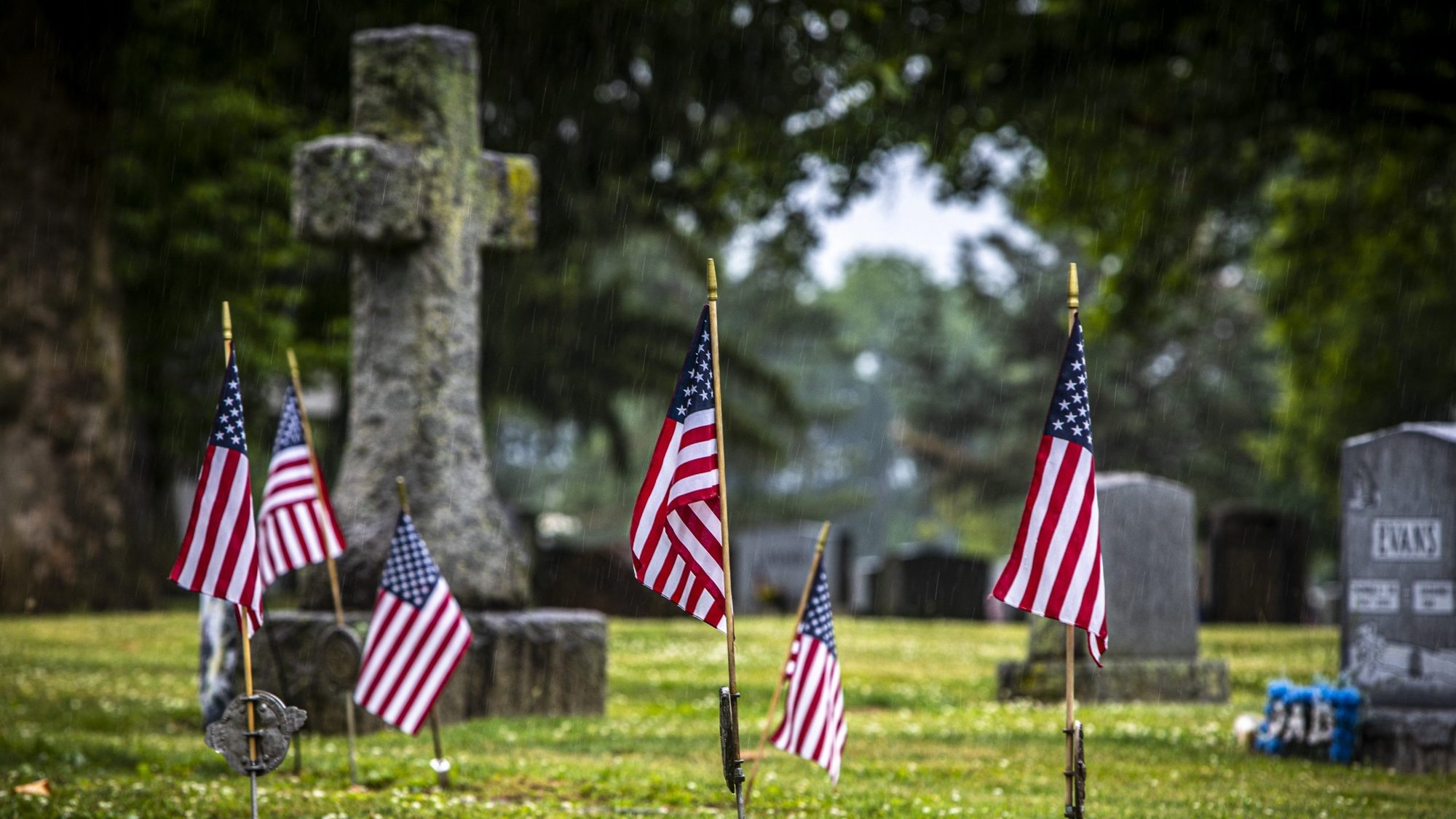 American flags are placed by headstones in Holy Saviour Cemetery in Bethlehem, Pa., on a rainy July 1, 2021, ahead of the Fourth of July holiday. (CNS photo/Chaz Muth)