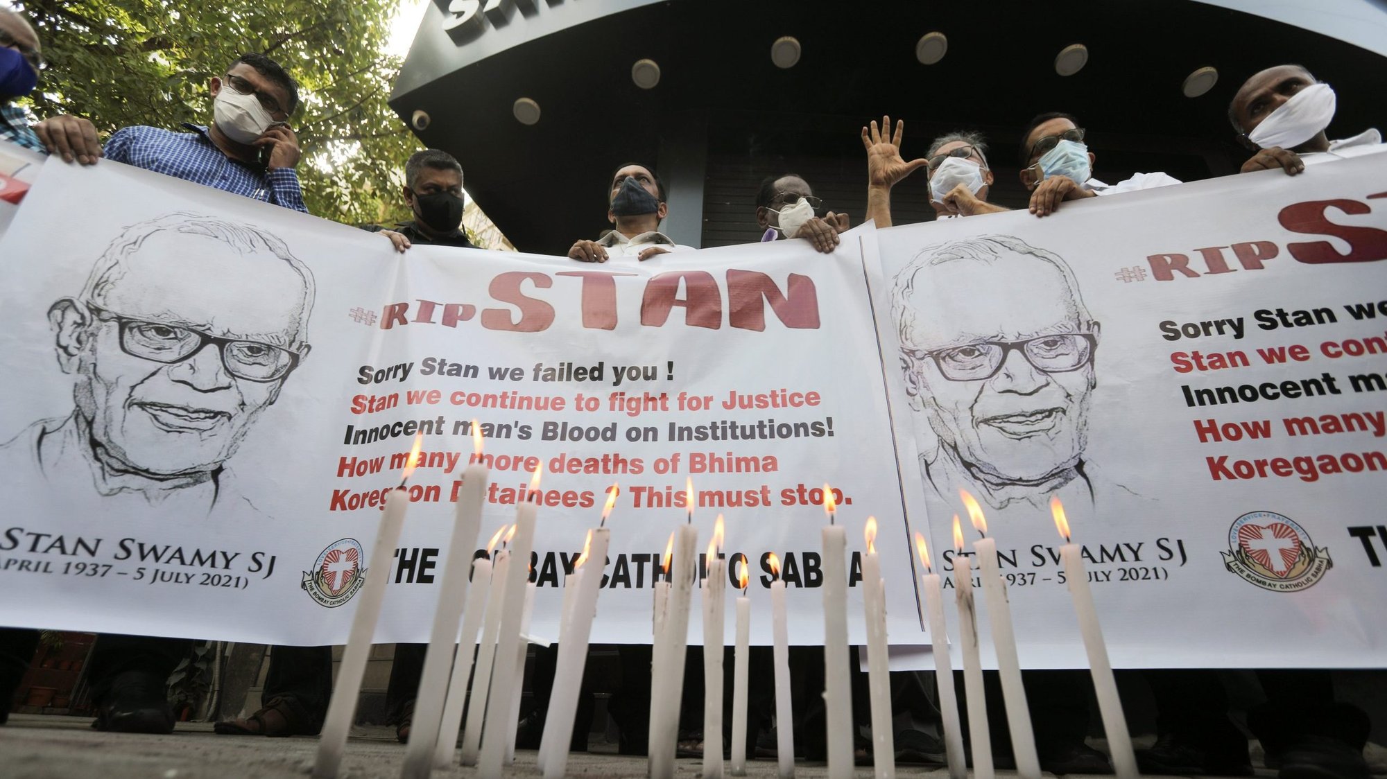 People hold a banner during a prayer service for Jesuit Father Stan Swamy in Mumbai, India, July 6, 2021, after he died at a hospital the previous day. The 84-year-old priest, who had been under detention on dubious terrorism charges since October, was been moved to the hospital from jail in late May, under orders from a local court. (CNS photo/Francis Mascarenhas, Reuters)