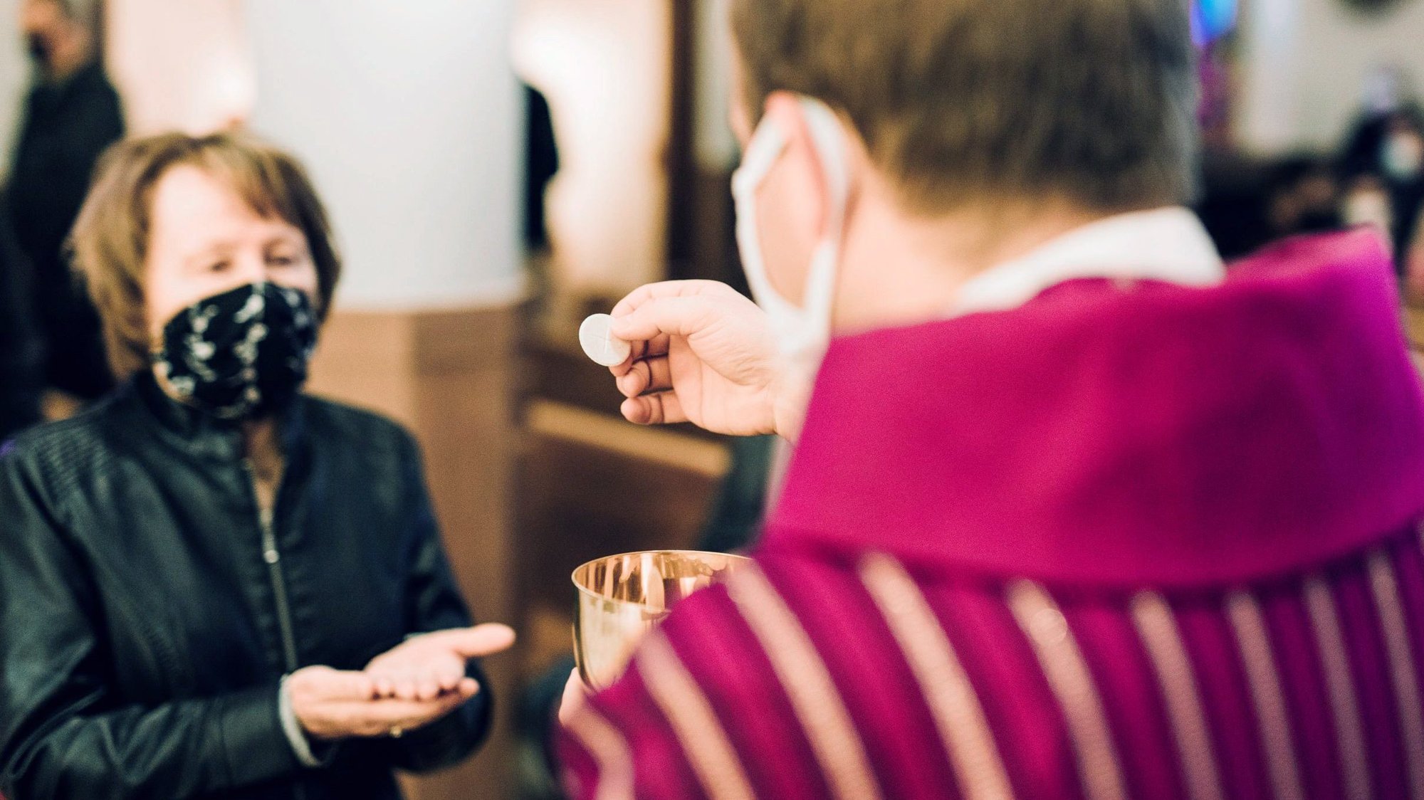 A woman receives Communion at St. John the Baptist Church in Monroe, Mich., amid the coronavirus pandemic. An understanding of the importance of the Eucharist is seen as key to Catholics returning to in-person Mass for the first time in more than a year. (CNS photo/courtesy Detroit Catholic)