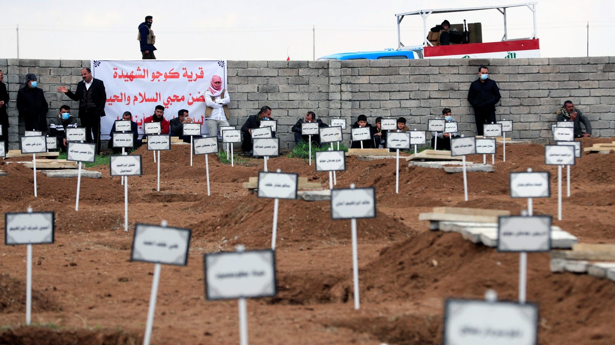 Men in Kojo, Iraq, gather Feb. 6, 2021, near the tombs of people from the Yazidi minority who were killed by Islamic State militants. Chaldean Catholic Archbishop Bashar Warda of Irbil, Iraq, in a July 14, 2021, address at the International Religious Freedom Summit in Washington that beyond Iraq's infrastructure needs, what needs to be rebuilt is the dignity of those who suffered under the Islamic State group. (CNS photo/Thaier al-Sudani, Reuters)