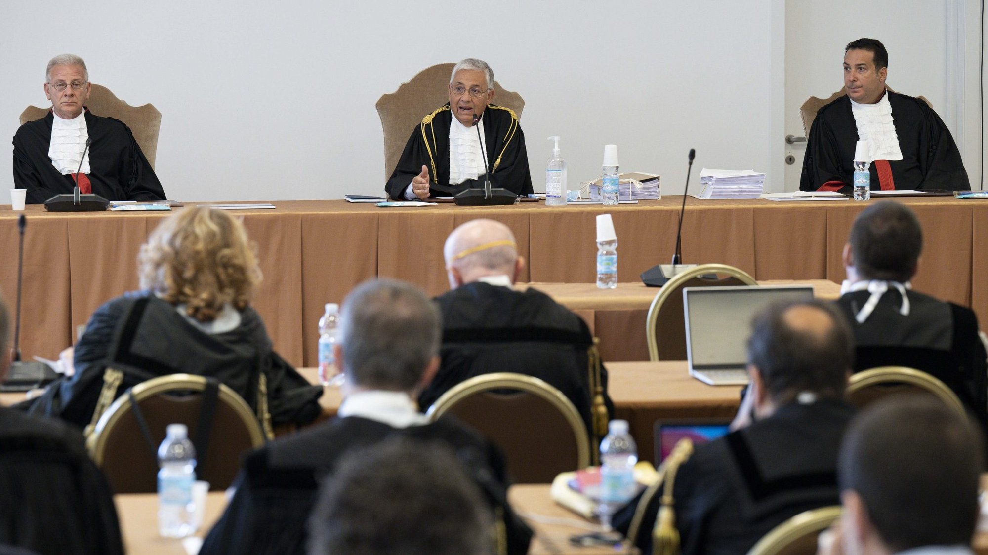 The judges of the Vatican City State criminal court -- Venerando Marano, Giuseppe Pignatone and Carlo Bonzano -- face dozens of lawyers in a makeshift Vatican courtroom July 27, 2021, as the trial of 10 defendants in a financial malfeasance case begins. Cardinal Angelo Becciu is among the defendants. (CNS photo/Vatican Media)