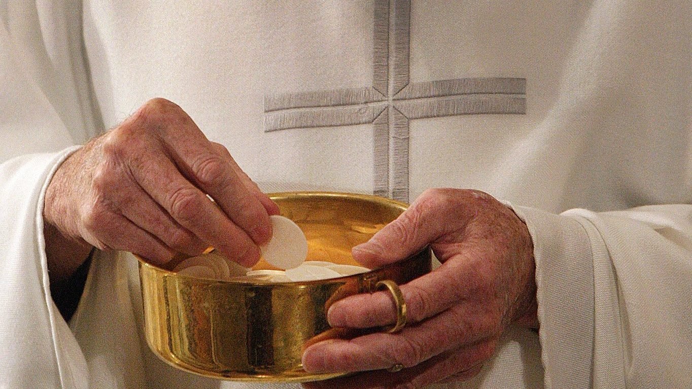 A priest prepares to distribute Communion during Mass in Washington in this 2011 photo. (CNS photo/Bob Roller)