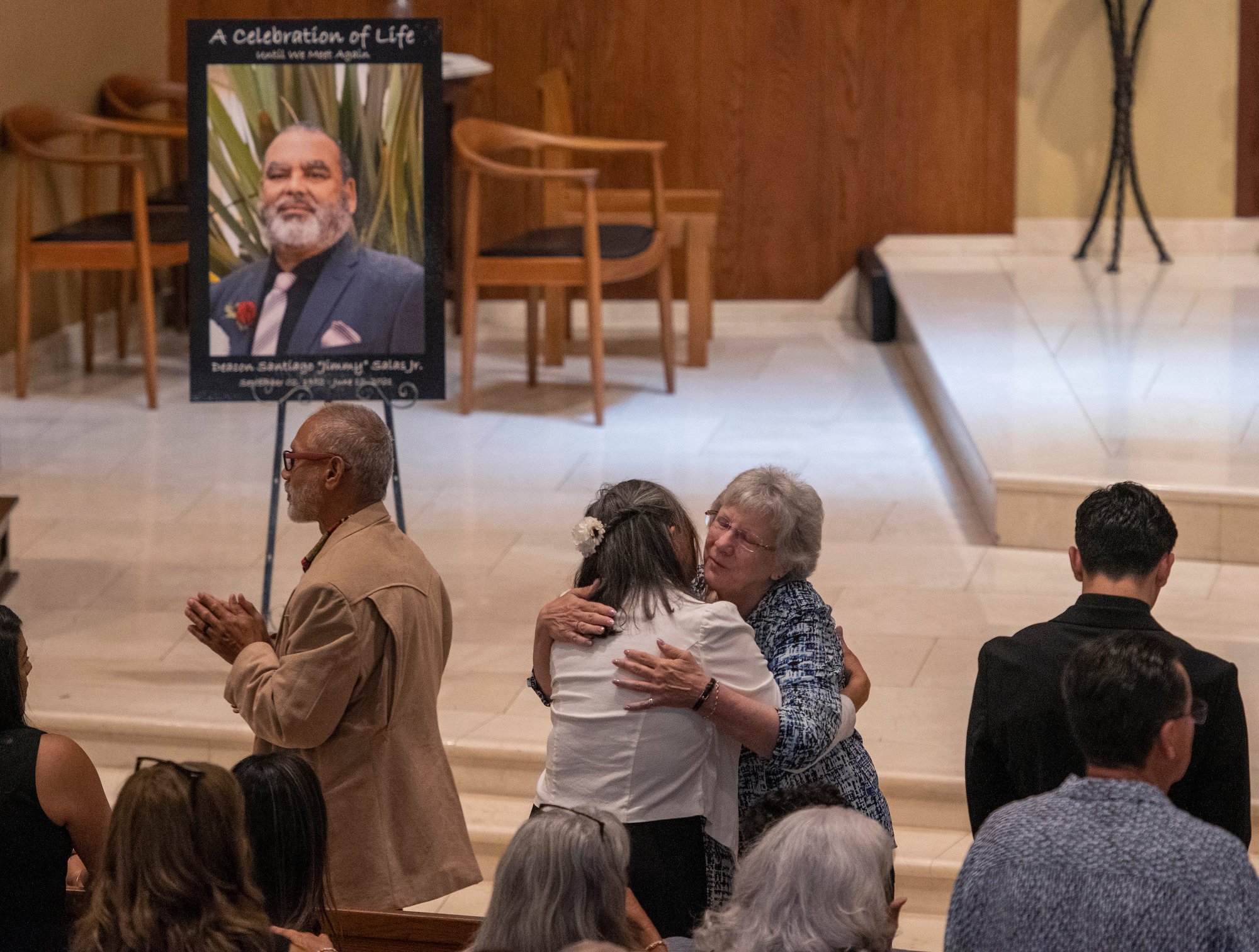 Mourners embrace at the funeral for Deacon Santiago “Jimmy” Salas at St. Cyprian Church in Long Beach on June 25. (Mike Goulding)