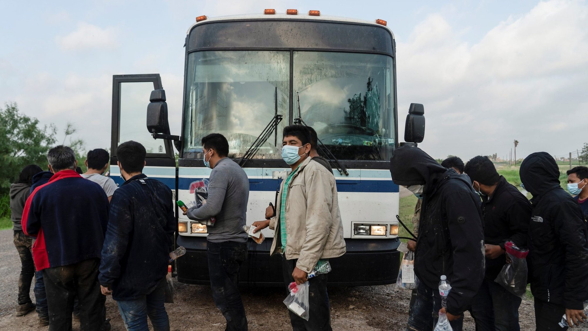 Central American migrants make a line to board a bus to be transported by U.S. Border Patrol agents after crossing the Rio Grande into the United States from Mexico, in La Joya, Texas, June 8, 2021. (CNS photo/Go Nakamura, Reuters)