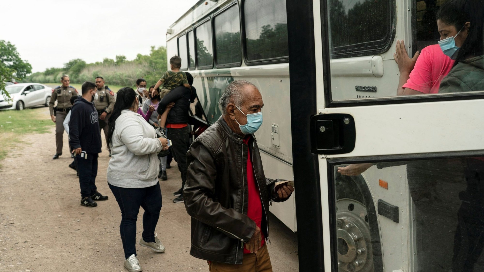 Migrant families from Venezuela seeking asylum board a U.S. Border Patrol's bus in Del Rio, Texas, May 27, 2021, to be transported after crossing the Rio Grande into the United States from Mexico. (CNS photo/Go Nakamura, Reuters)